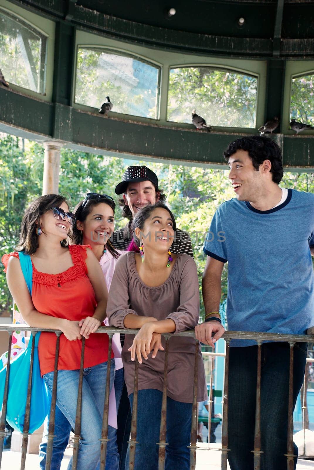 Close-up of three young women standing with two young men