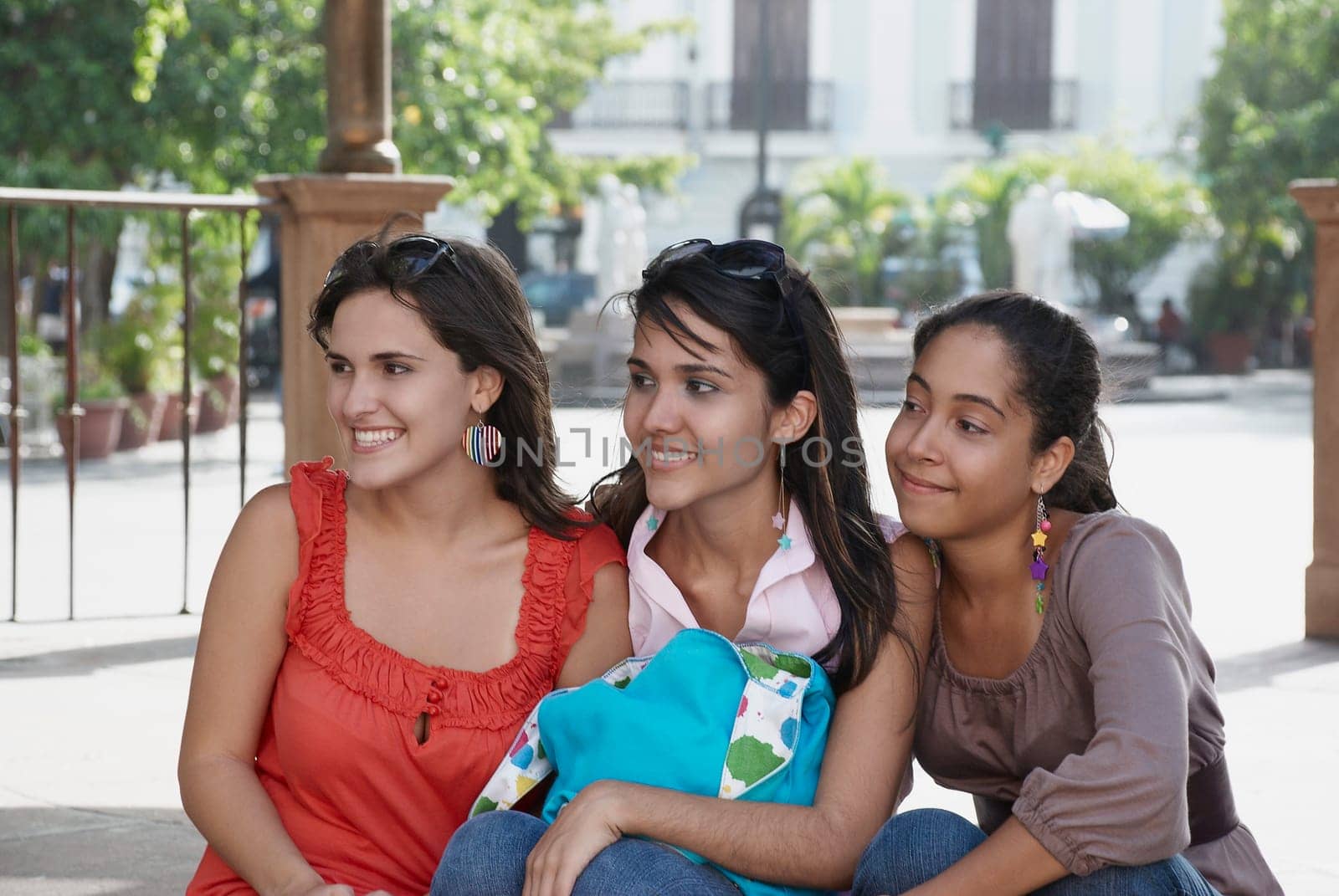 Close-up of three young women sitting and smiling