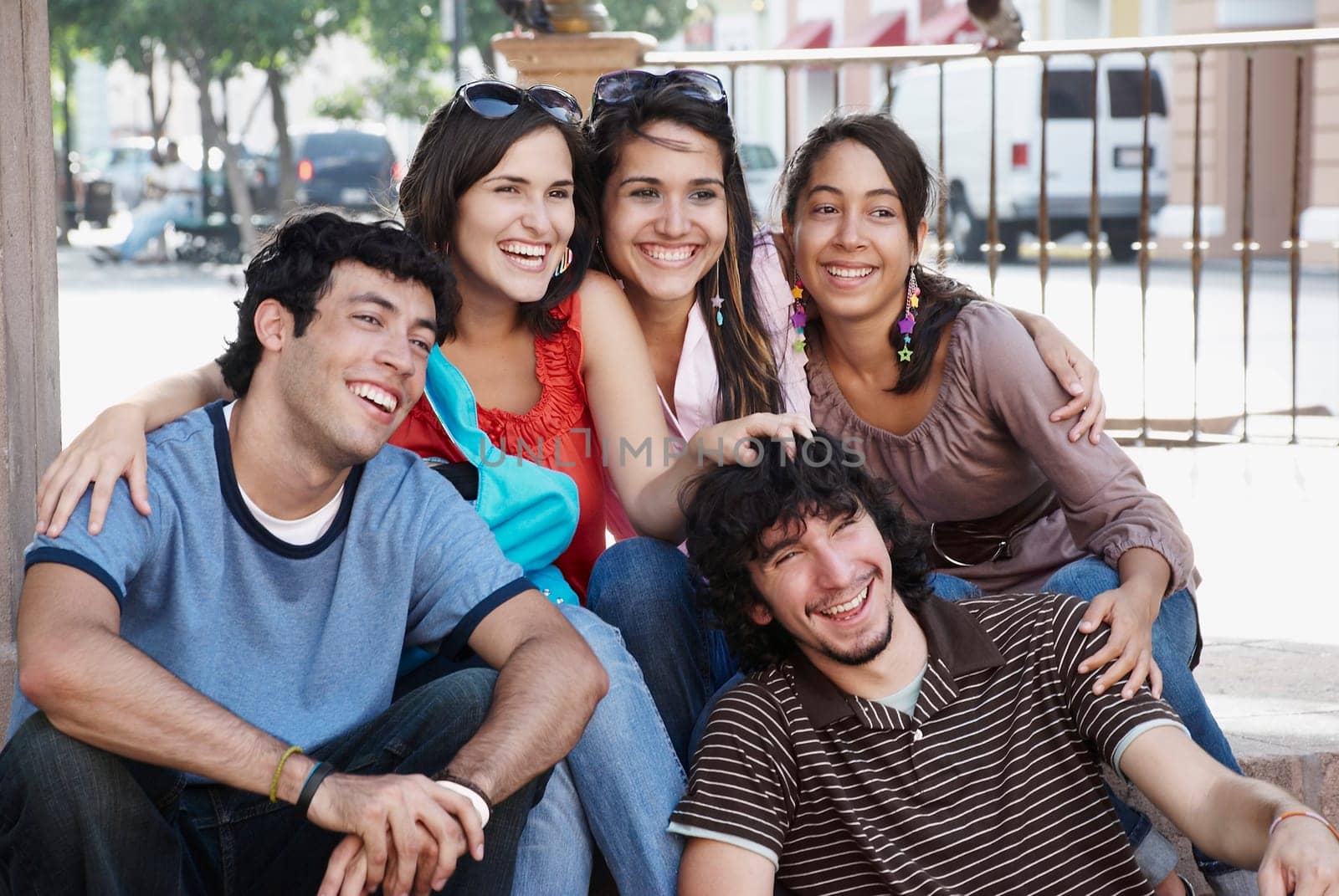 Close-up of three young women smiling with two young men