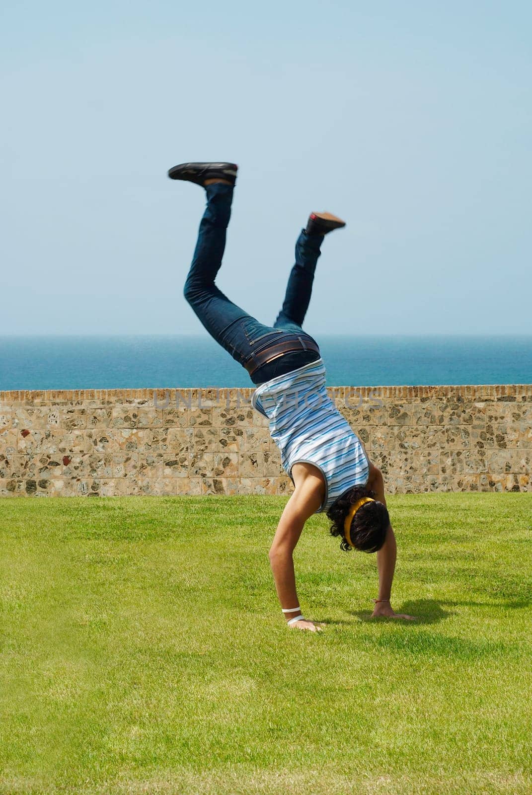 Rear view of a man doing a handstand in a park