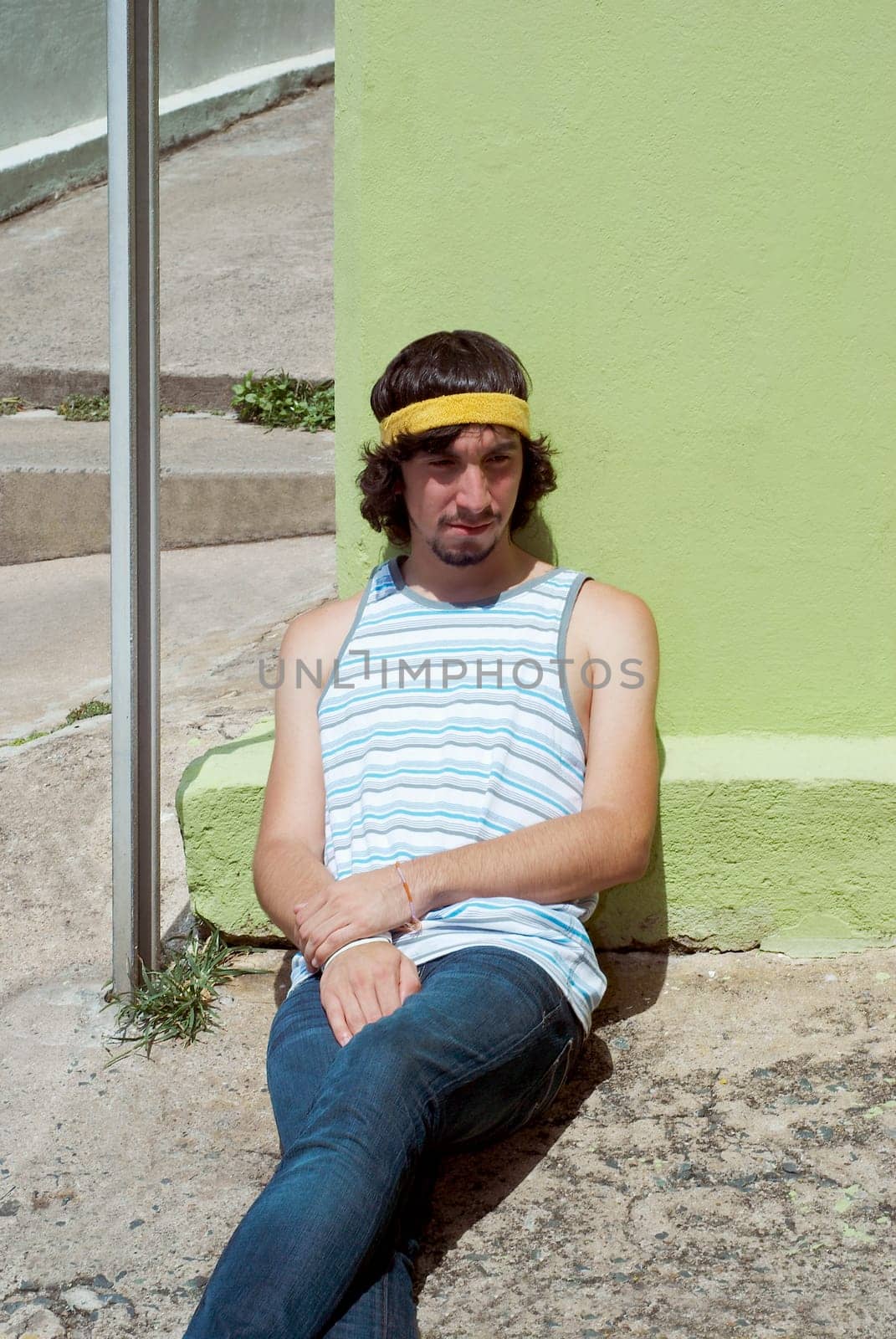 Young man leaning against a wall and thinking