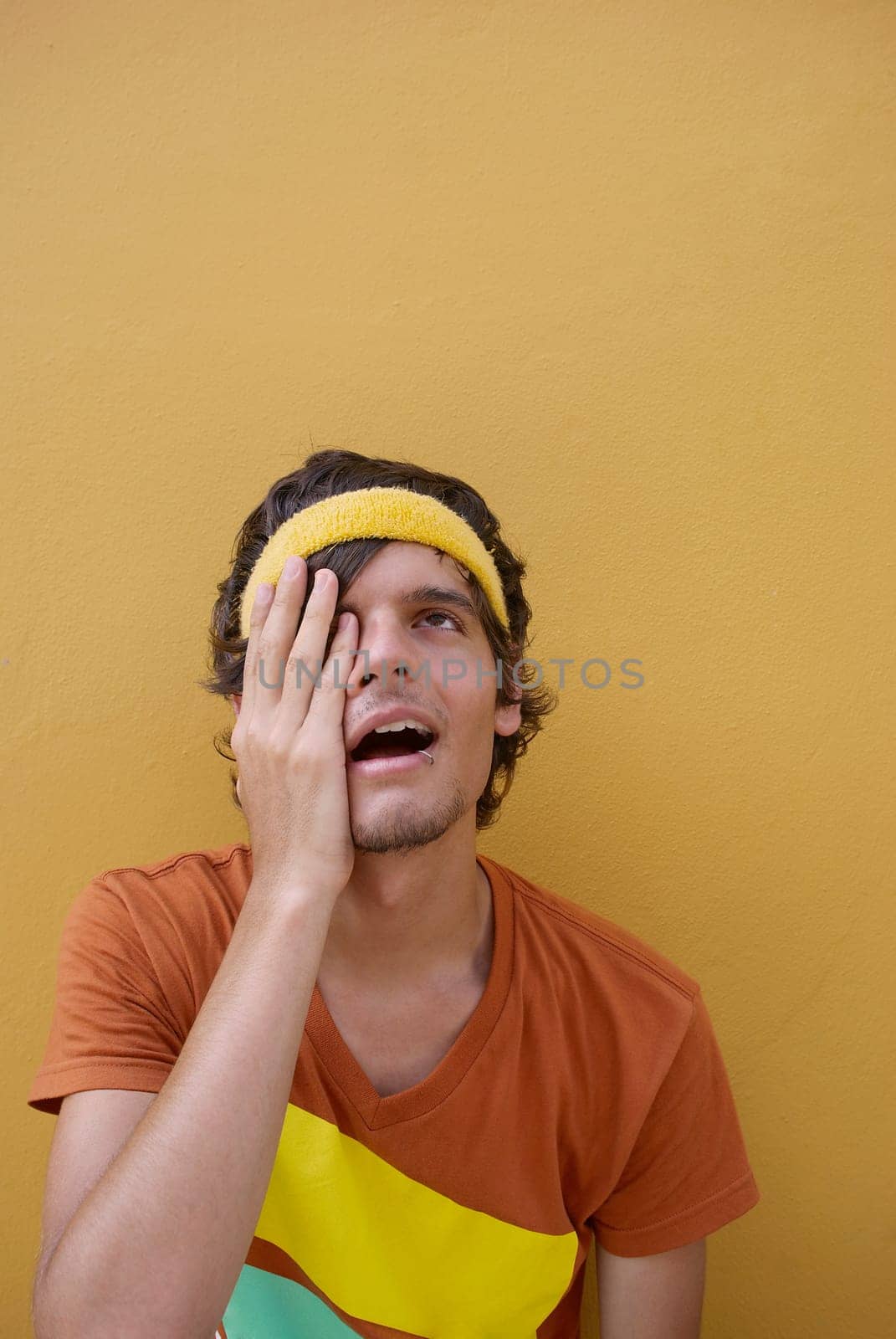 Close-up of a young man with his hand on his eye