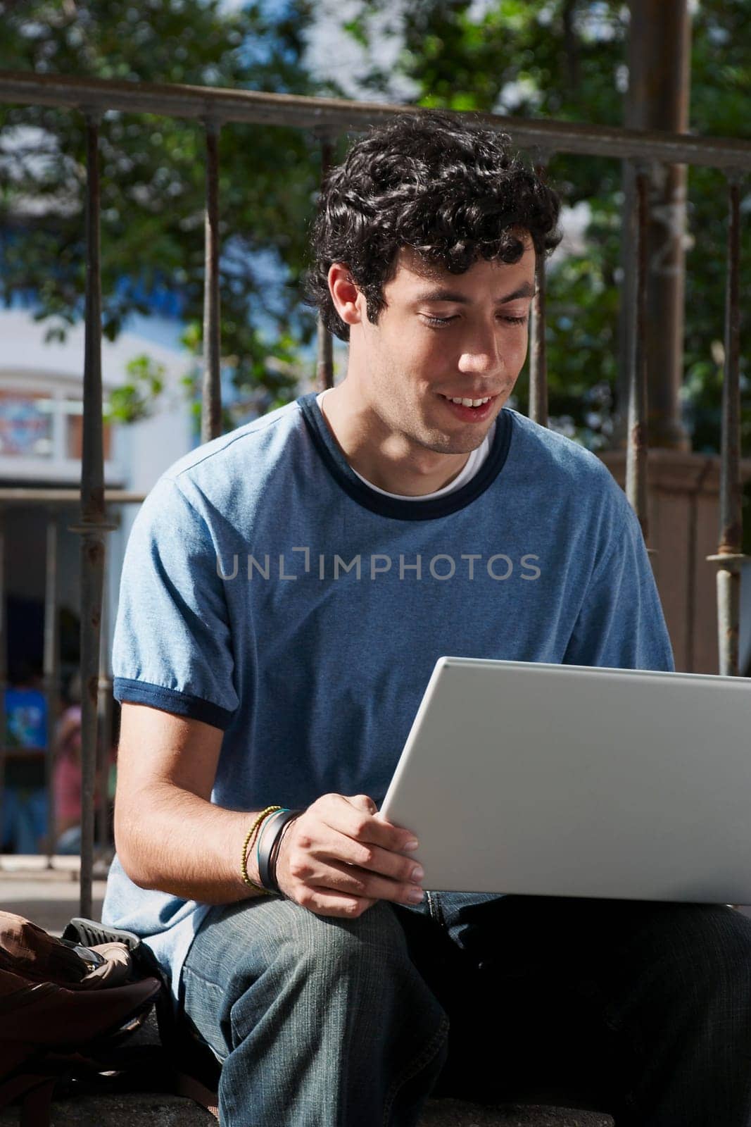 Close-up of a young man sitting and using a laptop