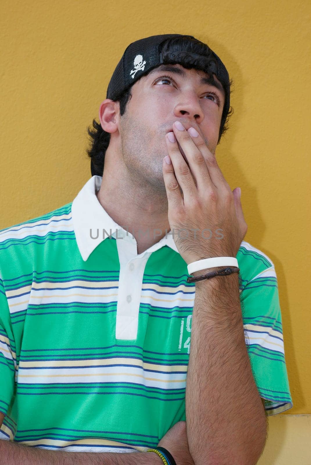 Close-up of a young man with his hands covering his mouth