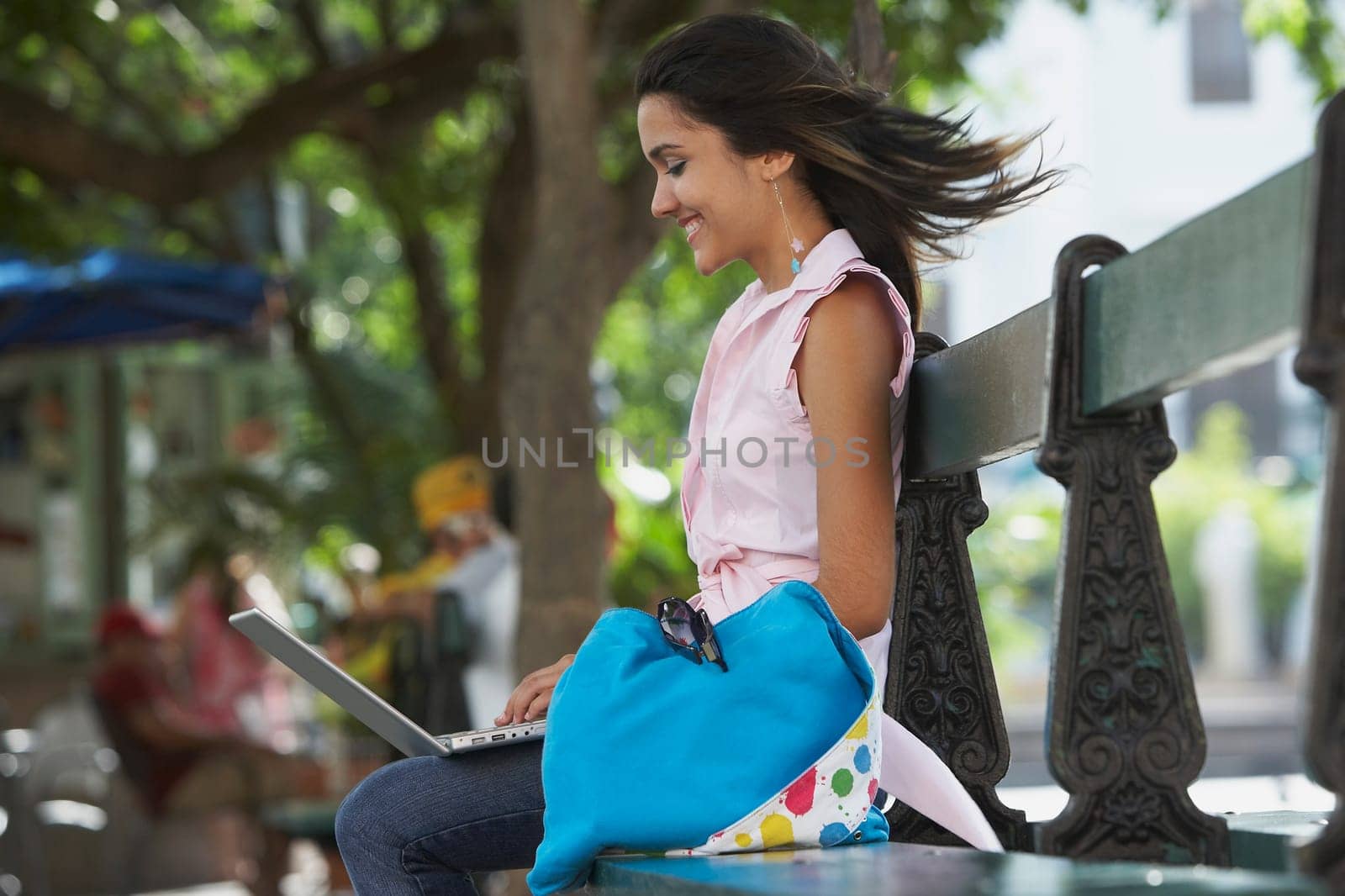 Side profile of a young woman sitting in a park and using a laptop, Old San Juan, San Juan, Puerto Rico