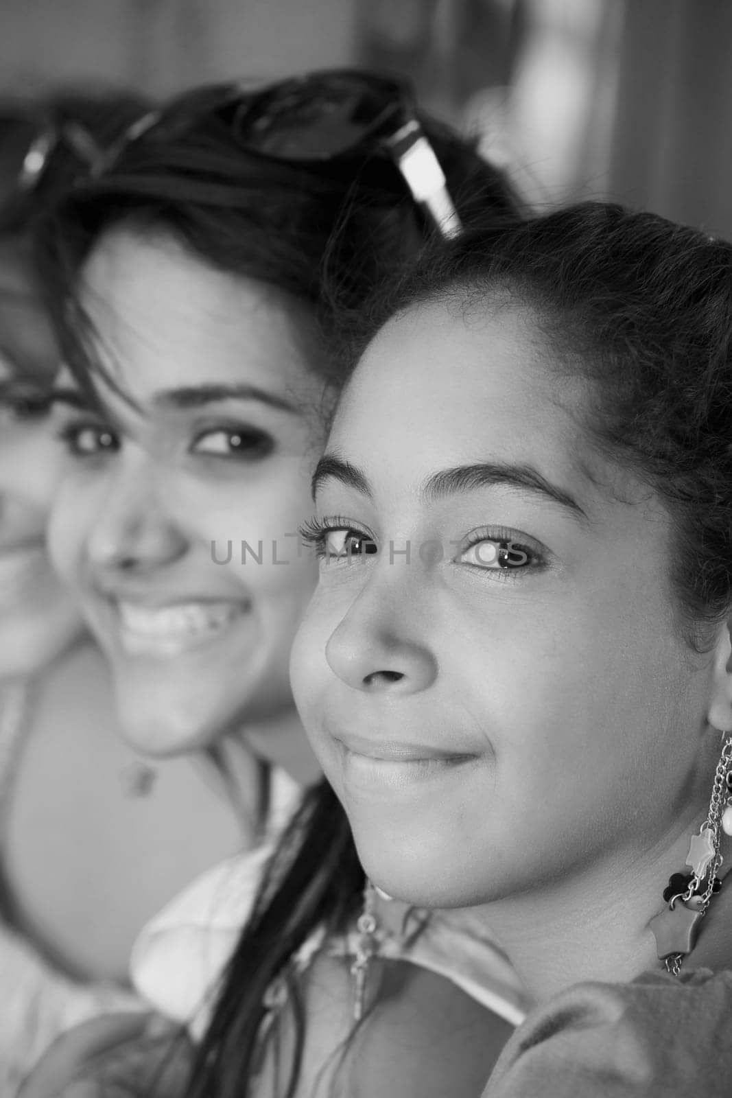 Portrait of a young woman grinning with her two friends smiling beside her