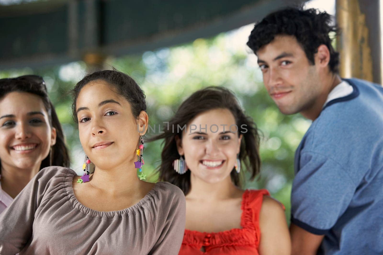 Portrait of a young man with three young women posing and smiling