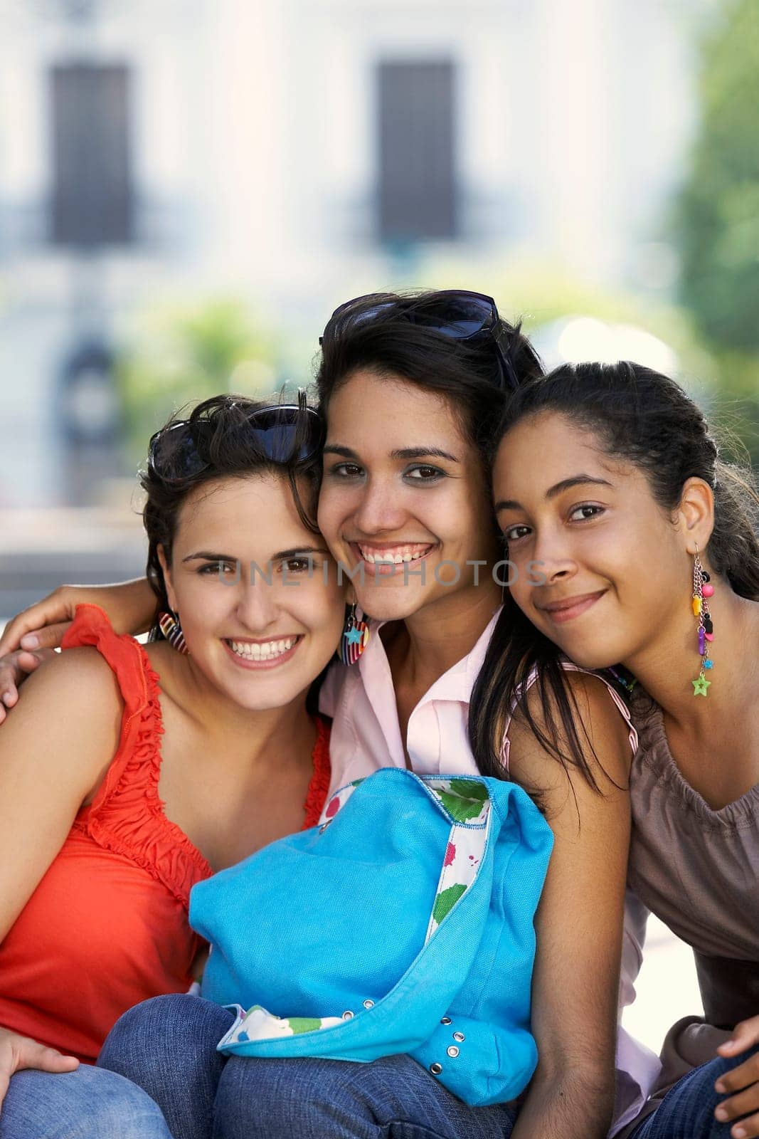 Portrait of three young women sitting and smiling