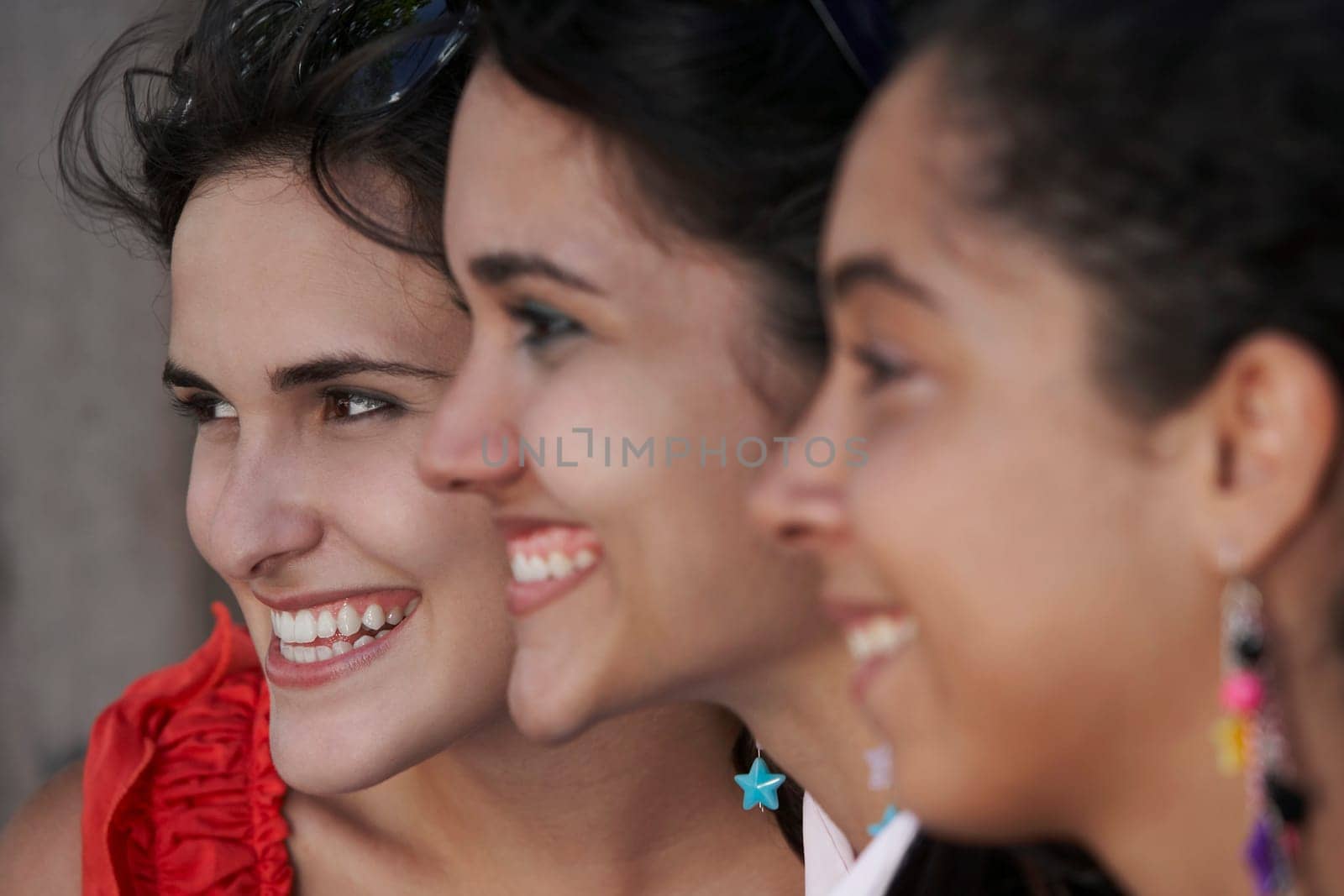 Side profile of three young women smiling