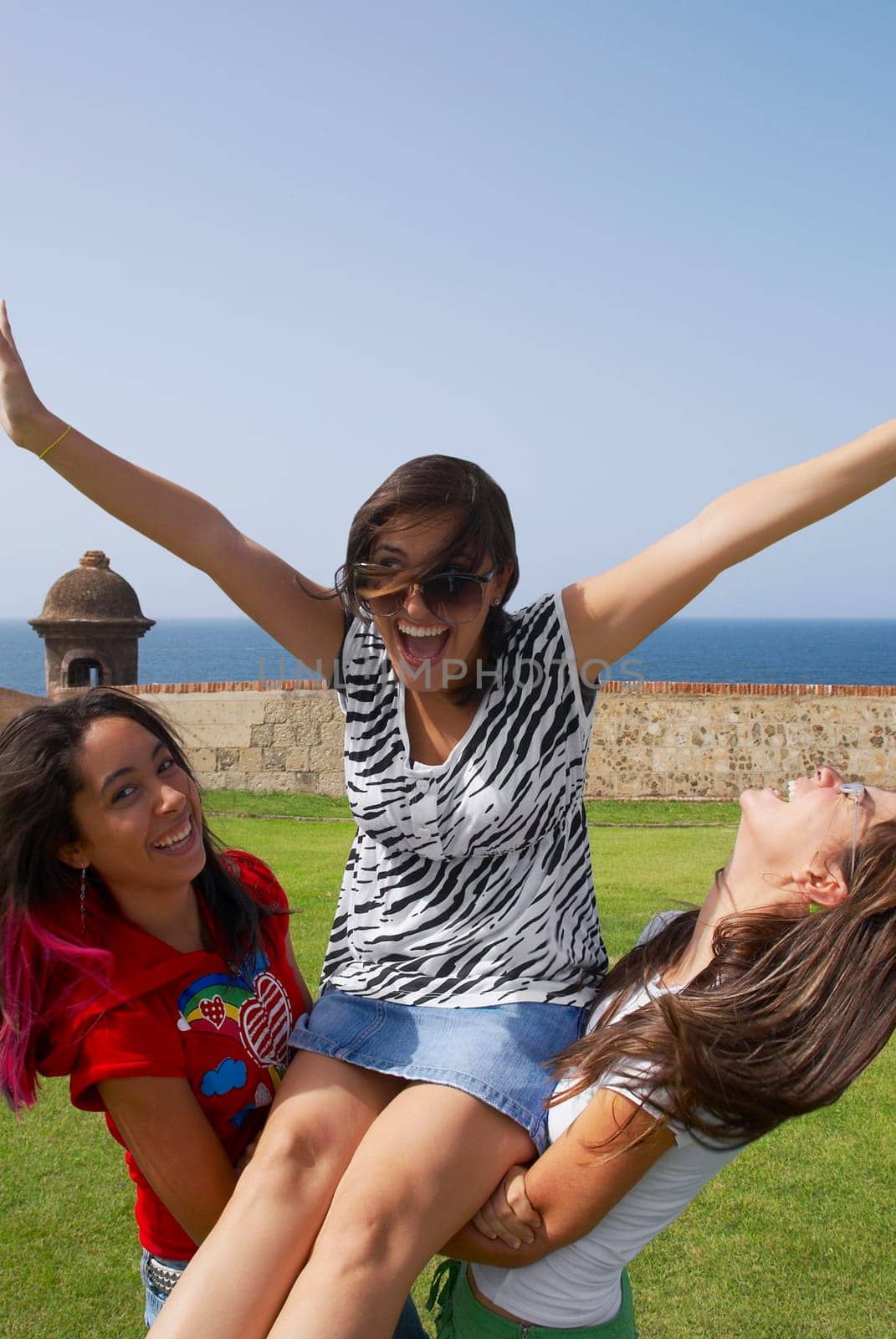 Side profile of two young women picking up another young woman, Morro Castle, Old San Juan, San Juan, Puerto Rico