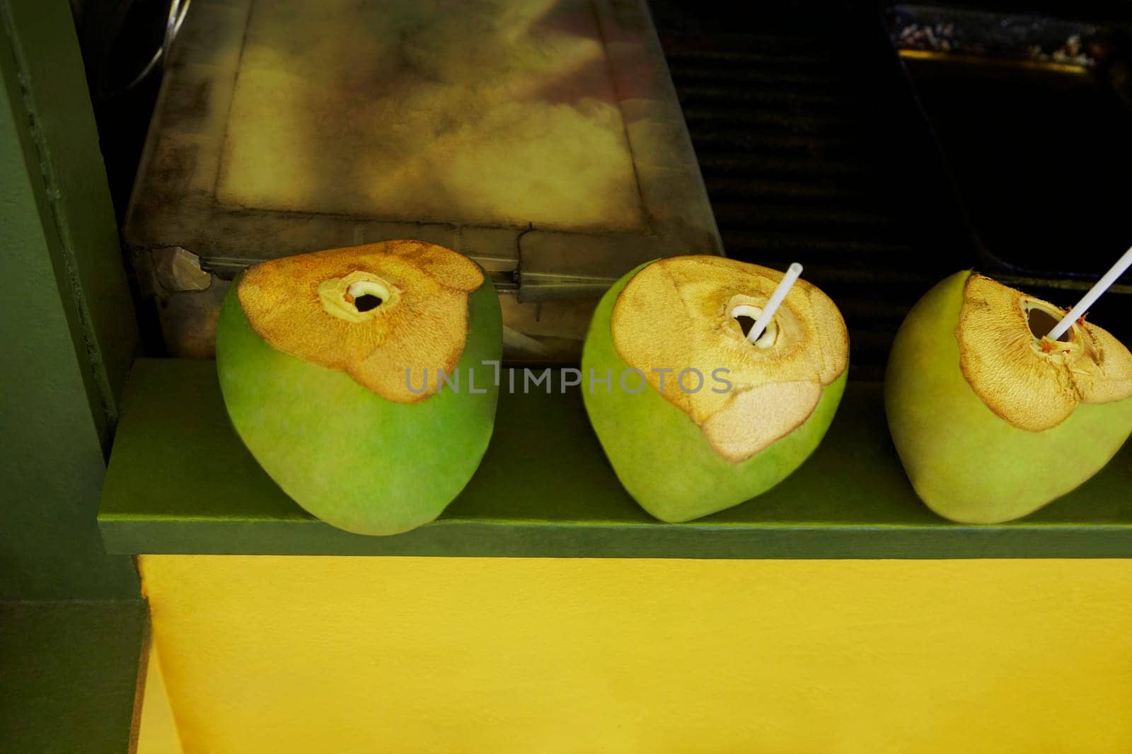 Drinking straws in green coconuts