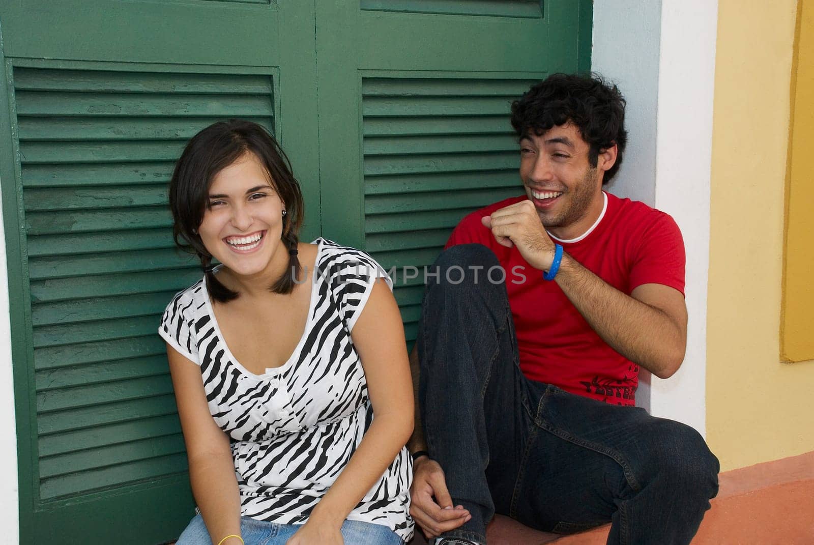 Young couple smiling in front of a door