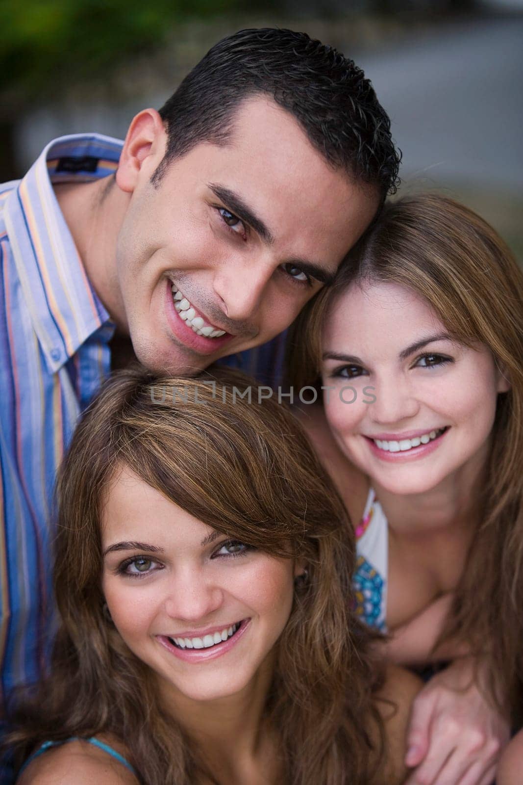 Portrait of a young man smiling with two young women