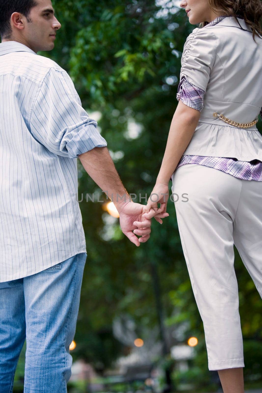 Rear view of a young couple holding hands of each other