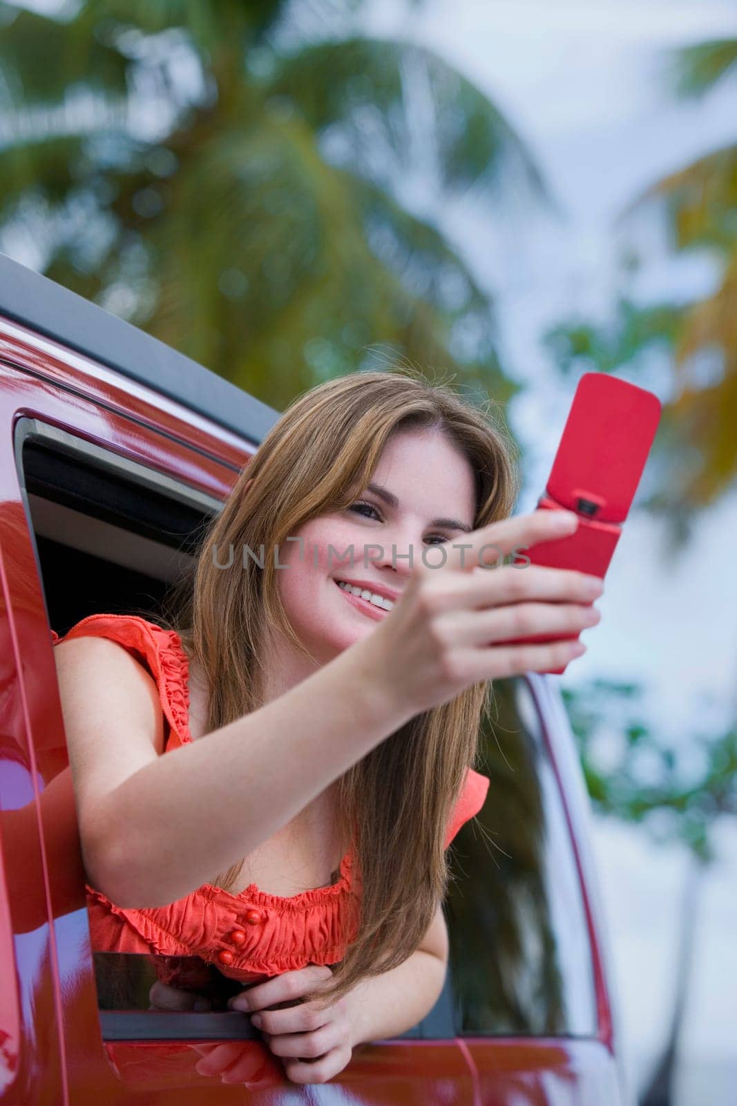 Young woman taking a picture with a mobile phone and smiling