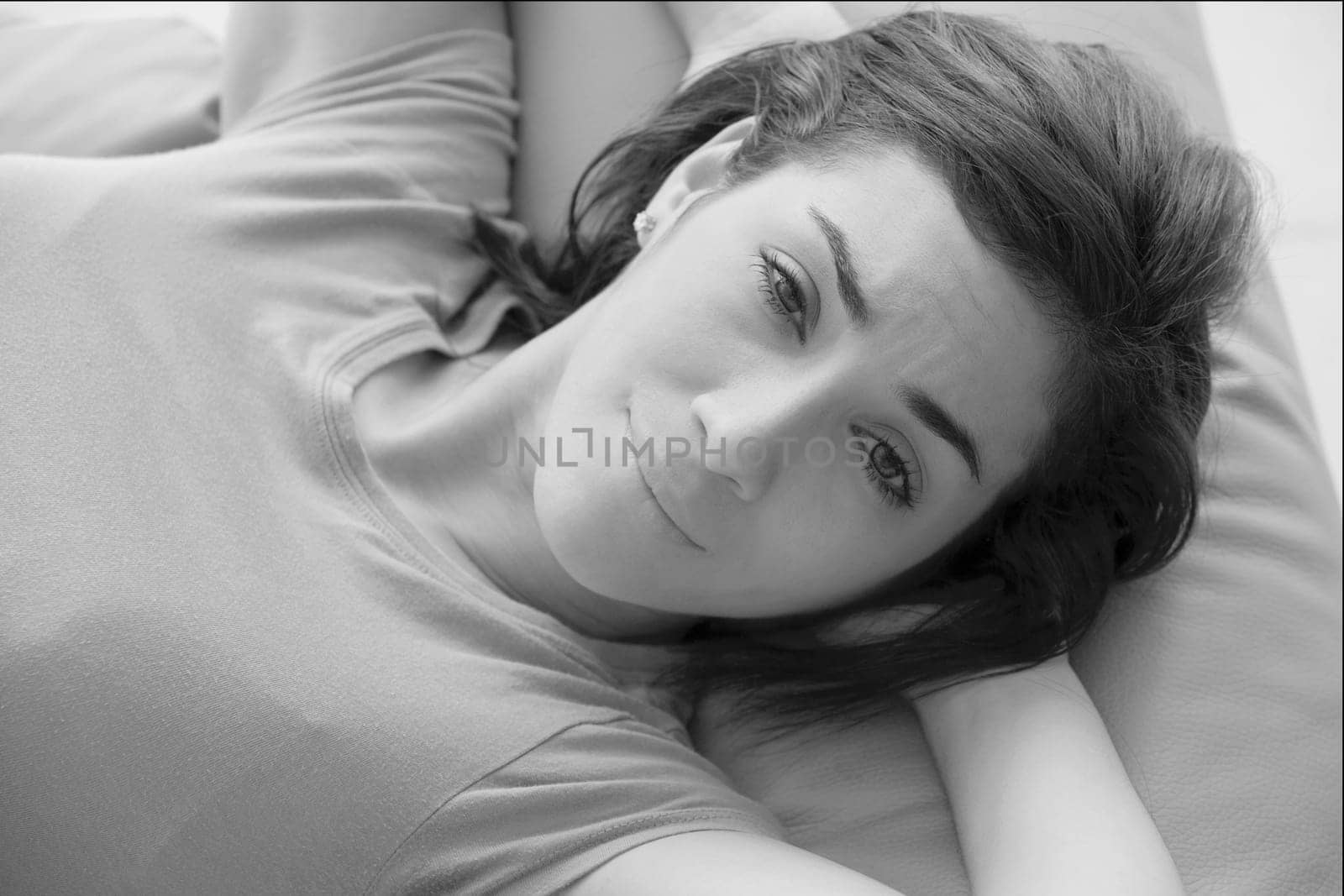 Portrait of a young woman lying on a couch and smirking