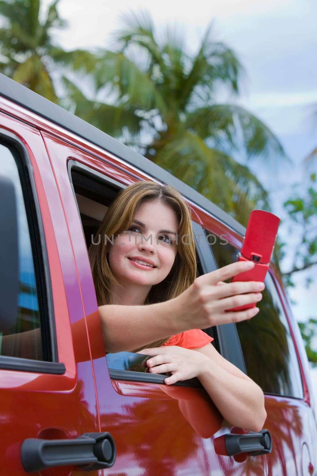 Young woman taking a picture with a mobile phone and looking away