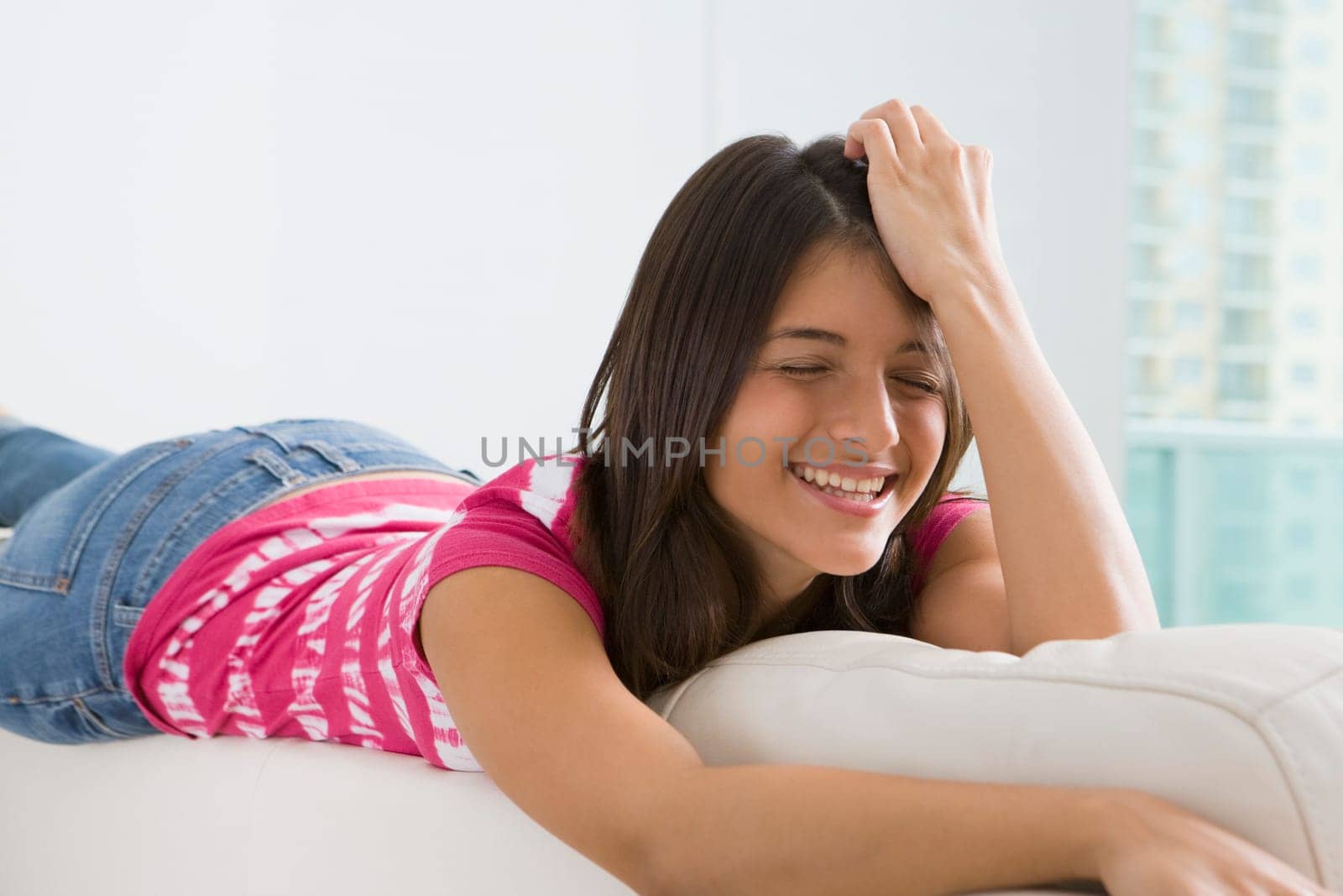 Teenage girl lying on a couch and smiling