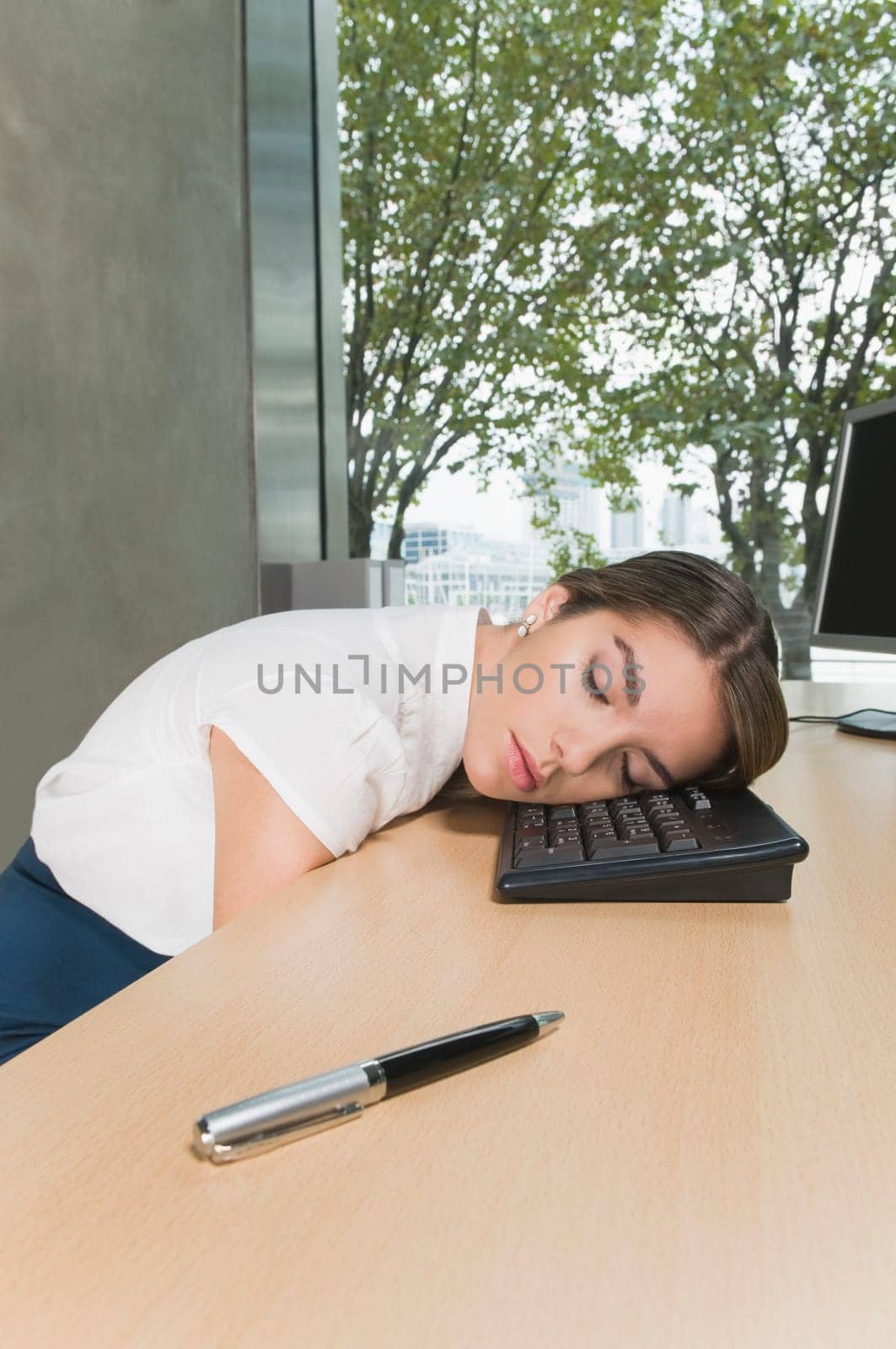Businesswoman sleeping on a desk in an office