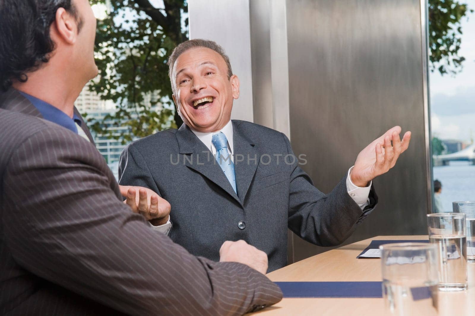 Two businessmen laughing in a conference room