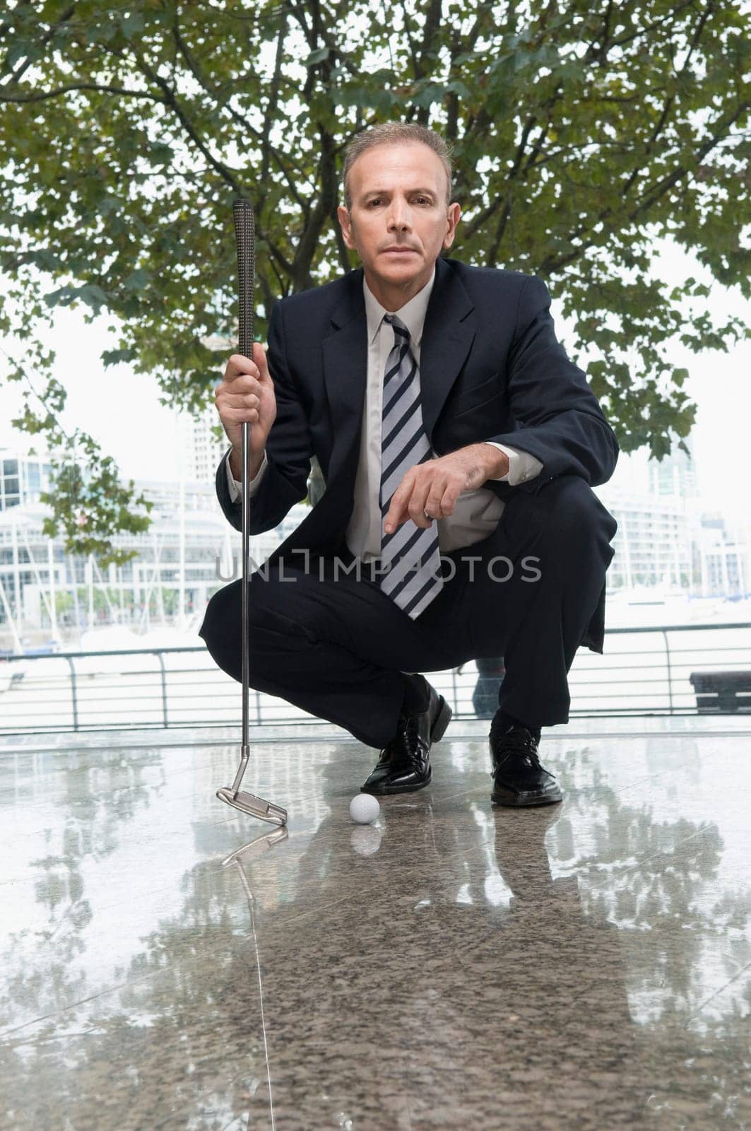 Businessman holding a golf club in an office