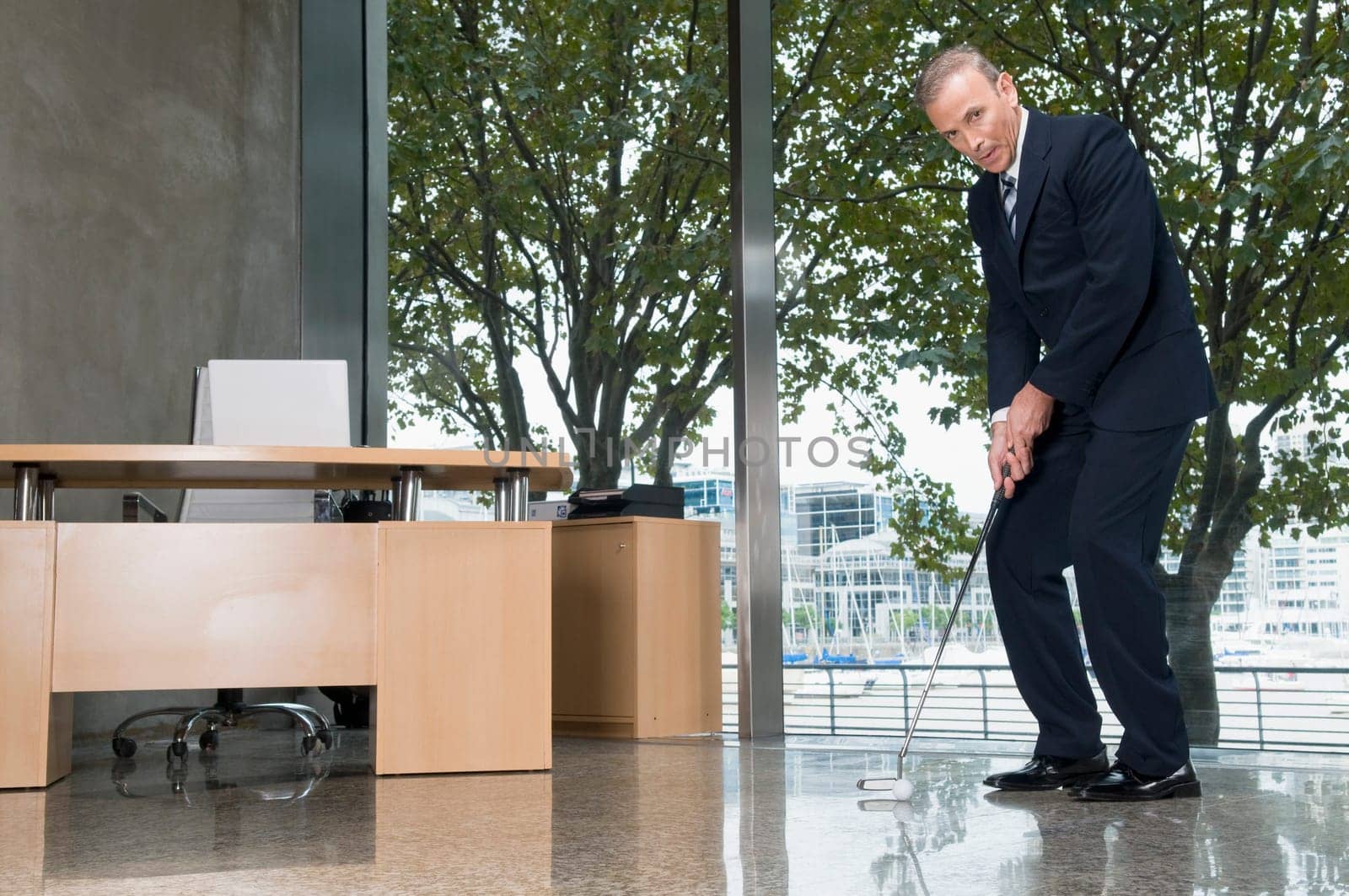 Businessman playing golf in an office
