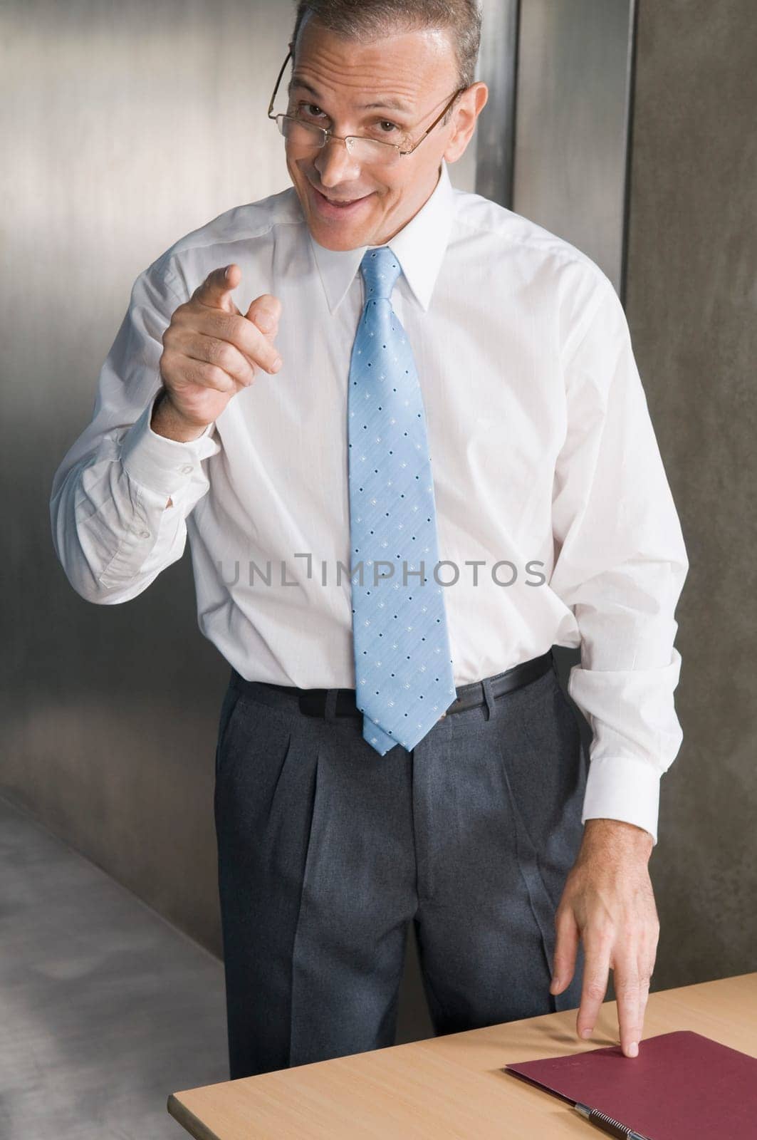Businessman smiling and pointing forward in an office