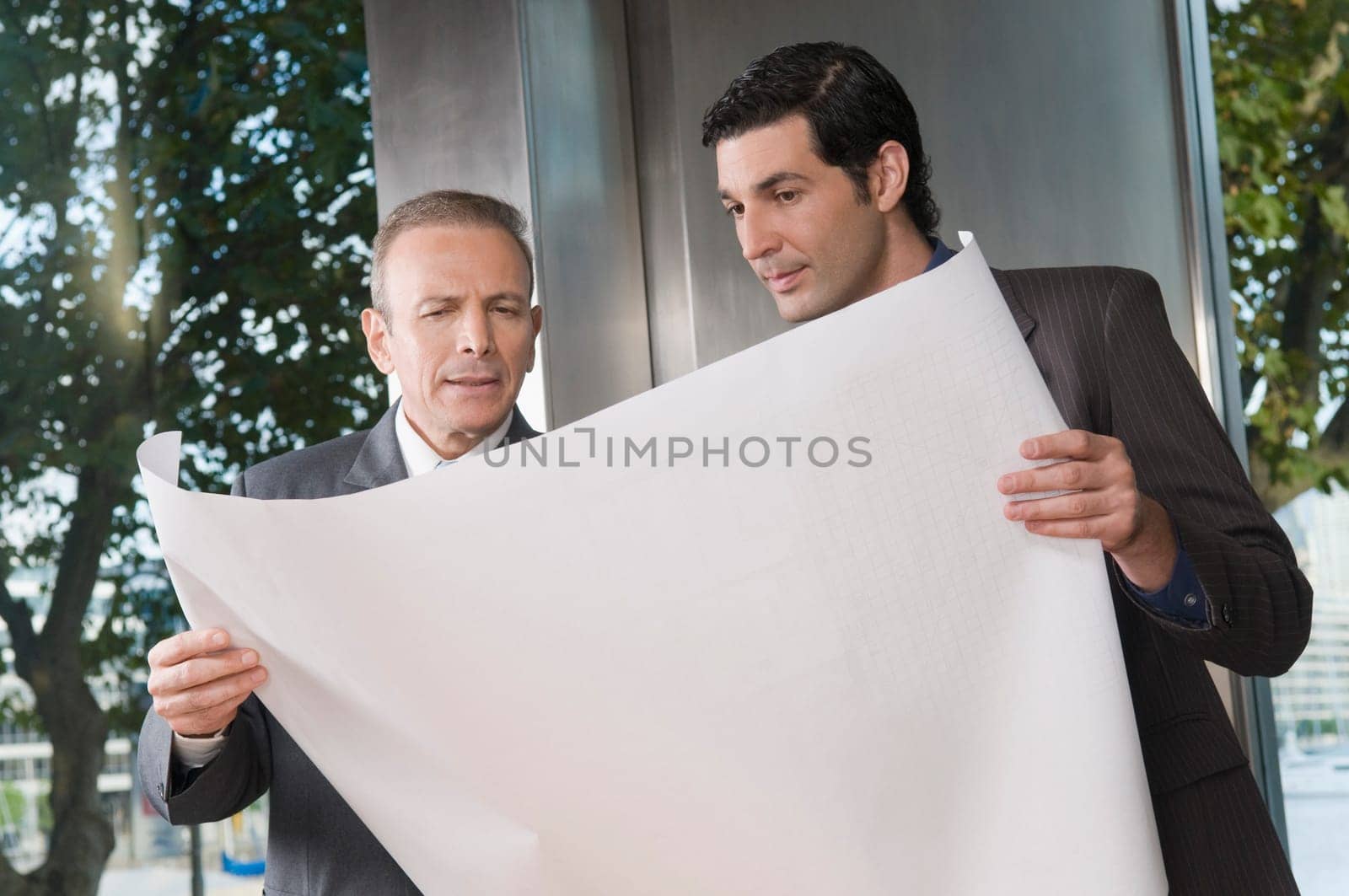 Two businessmen discussing a blueprint
