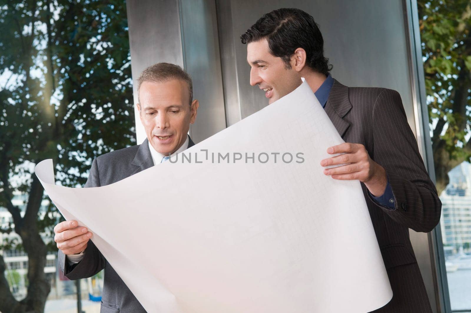 Two businessmen discussing a blueprint