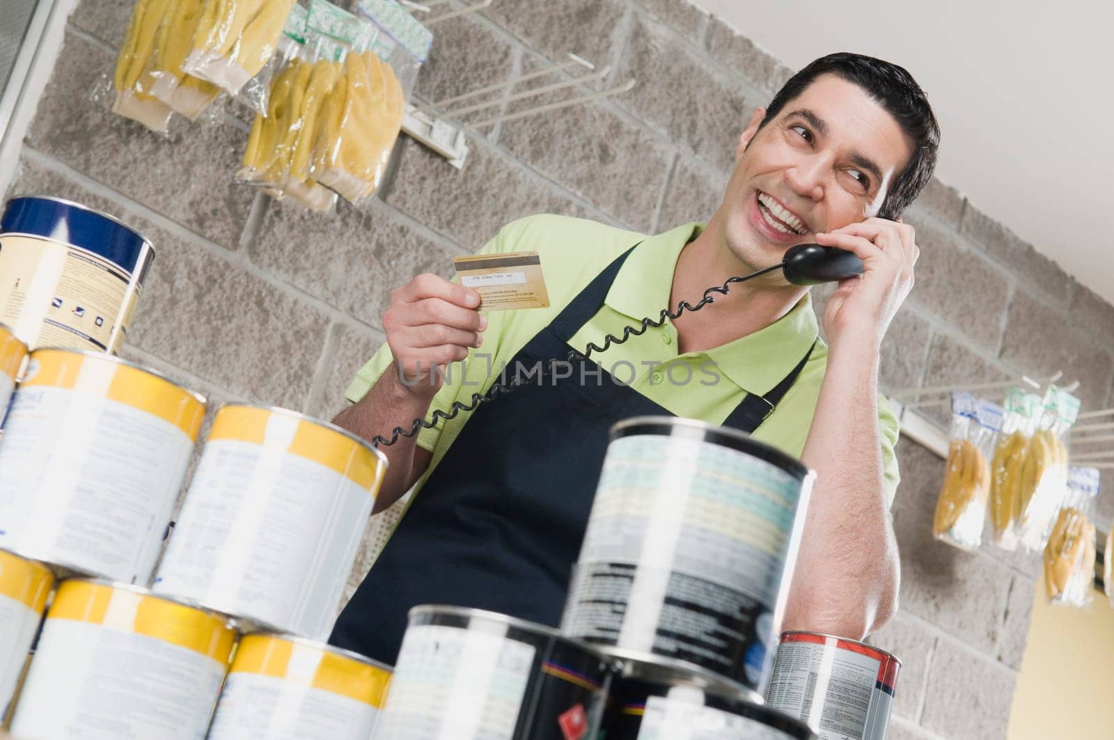Sales clerk talking on the telephone and holding a credit card