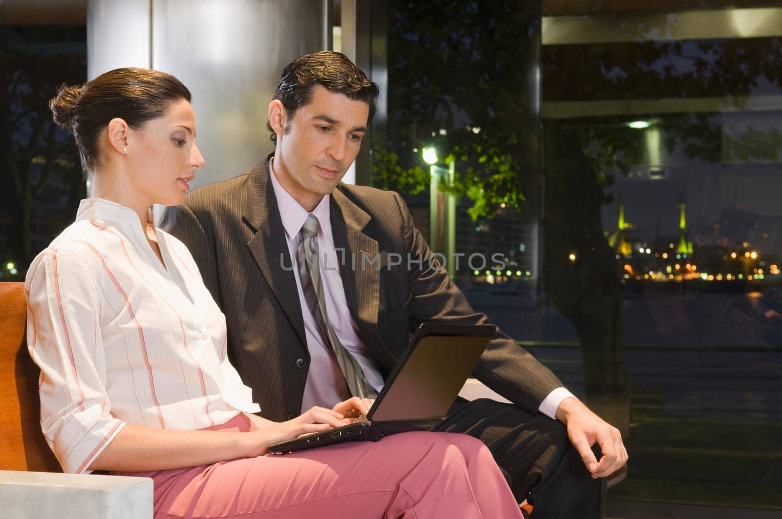 Business executives working on a laptop at an airport lounge