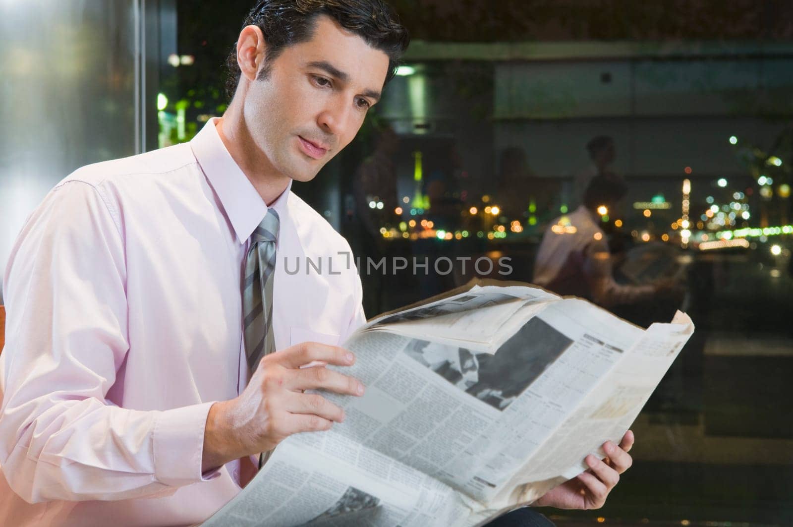 Businessman reading a newspaper at an airport lounge
