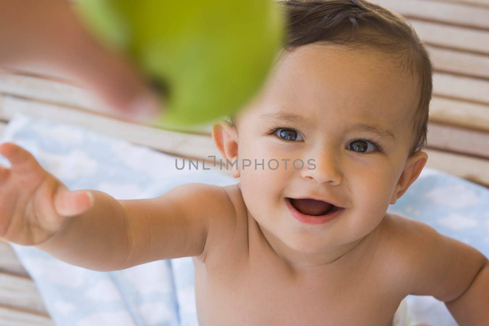 Baby boy reaching to hold an apple