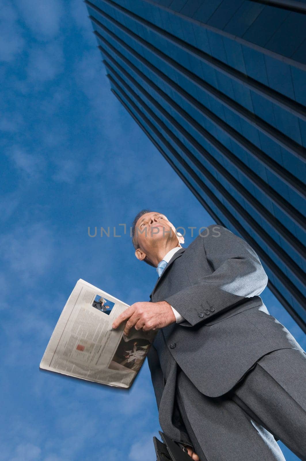 Low angle view of a businessman holding a newspaper
