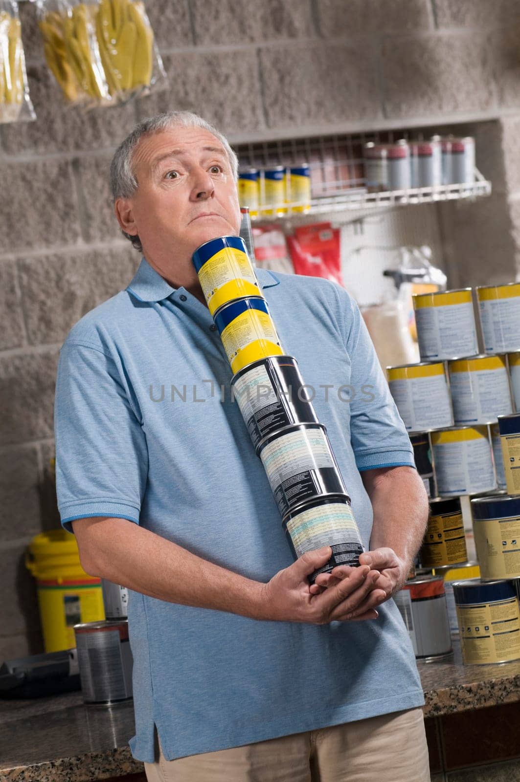 Man holding paint cans in a hardware store