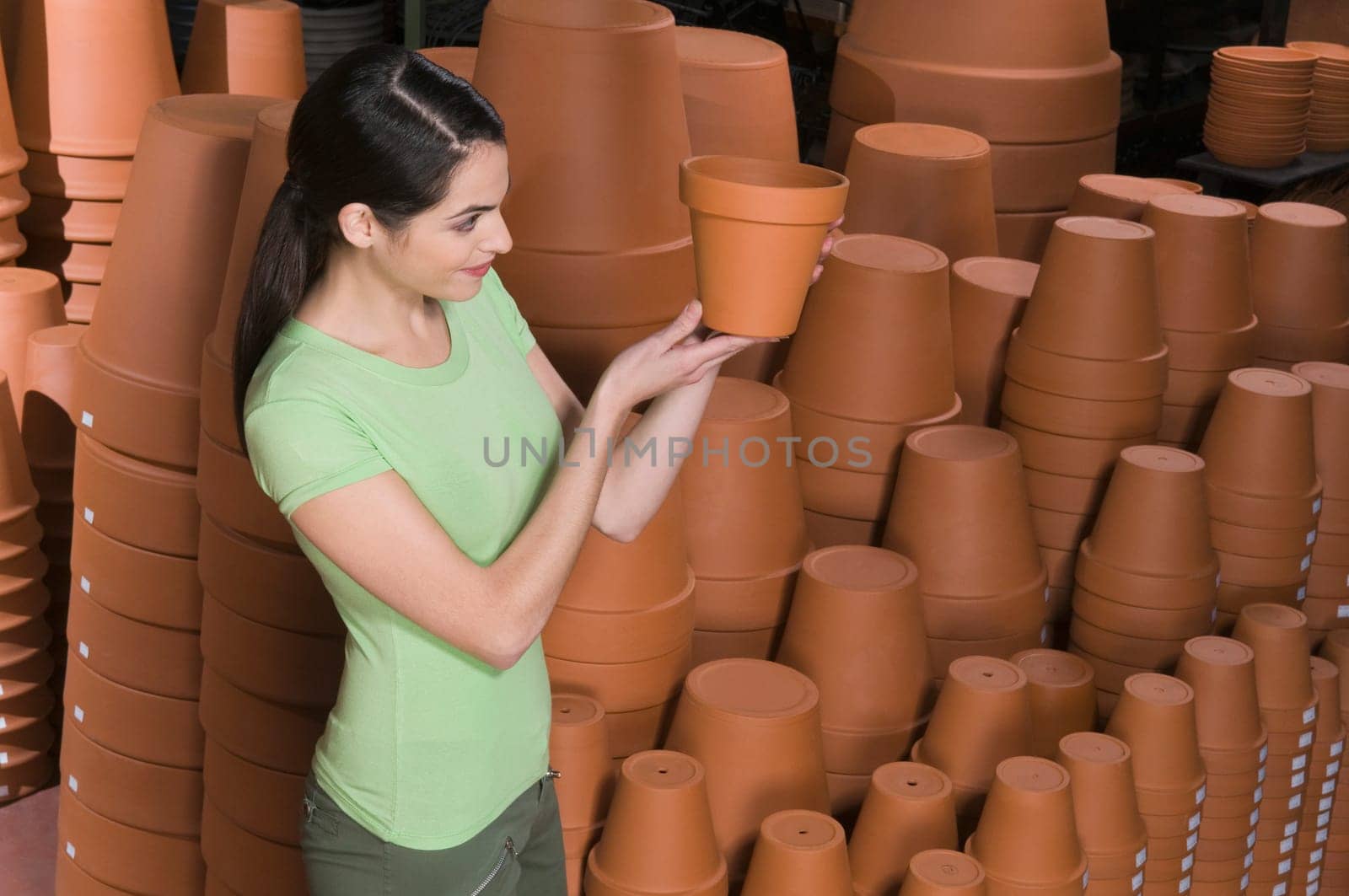 Young woman looking at flower pot in a garden center