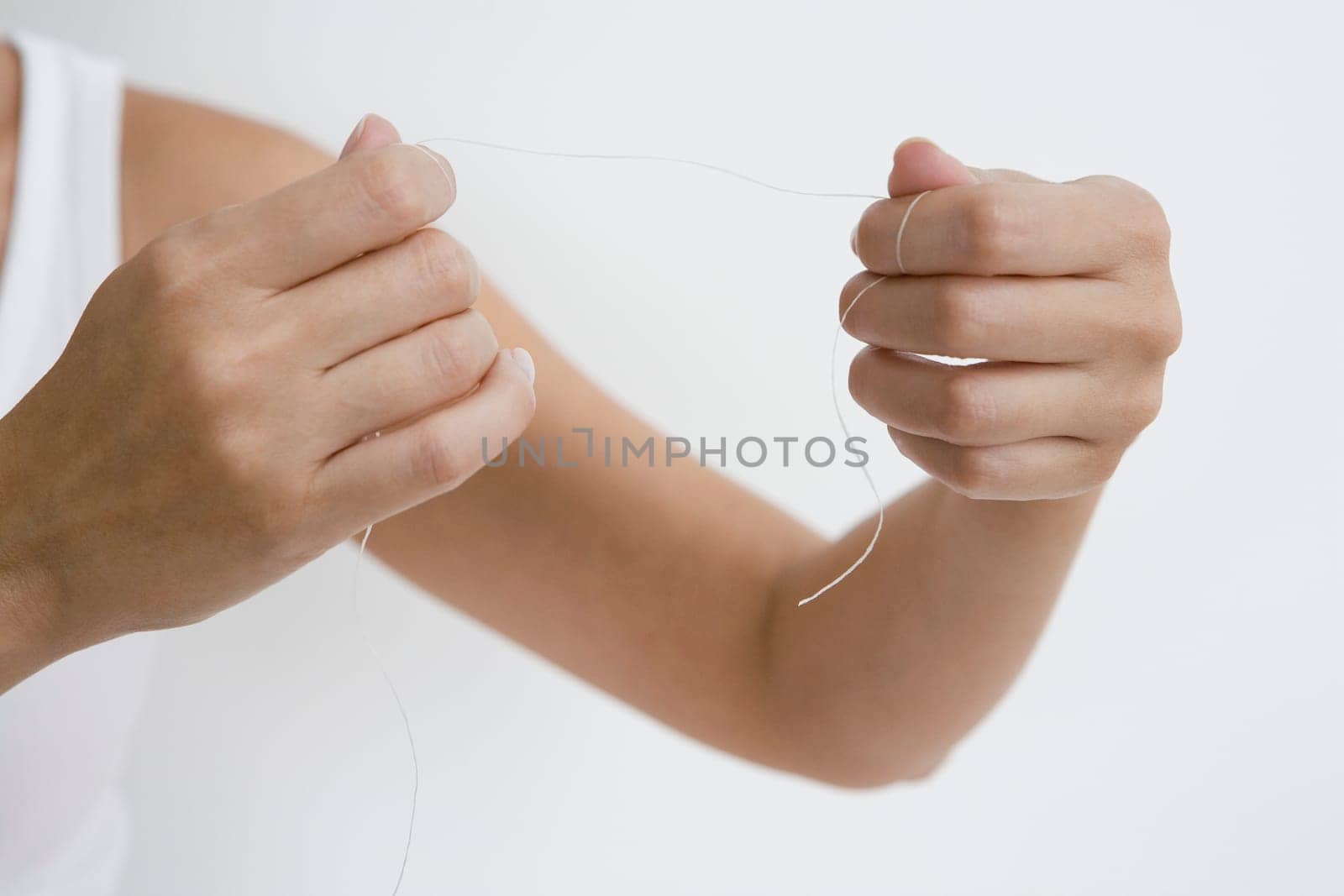 Close-up of a person's hand holding a dental floss