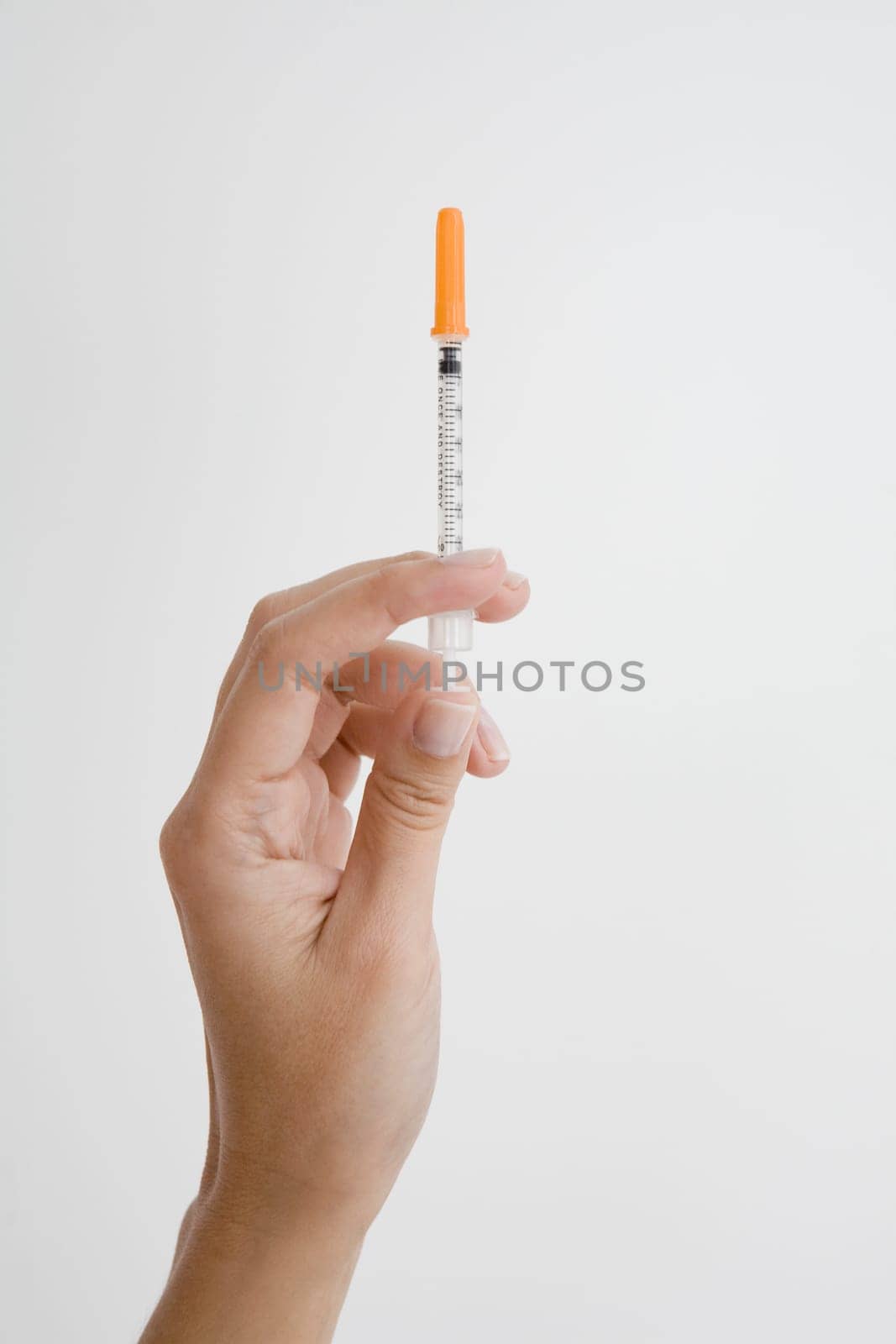 Close-up of a person's hand holding a syringe