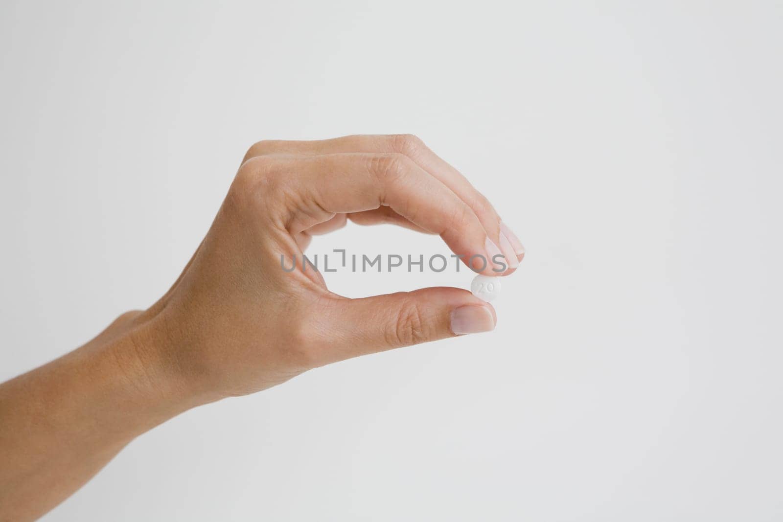 Close-up of a person's hand holding a pill