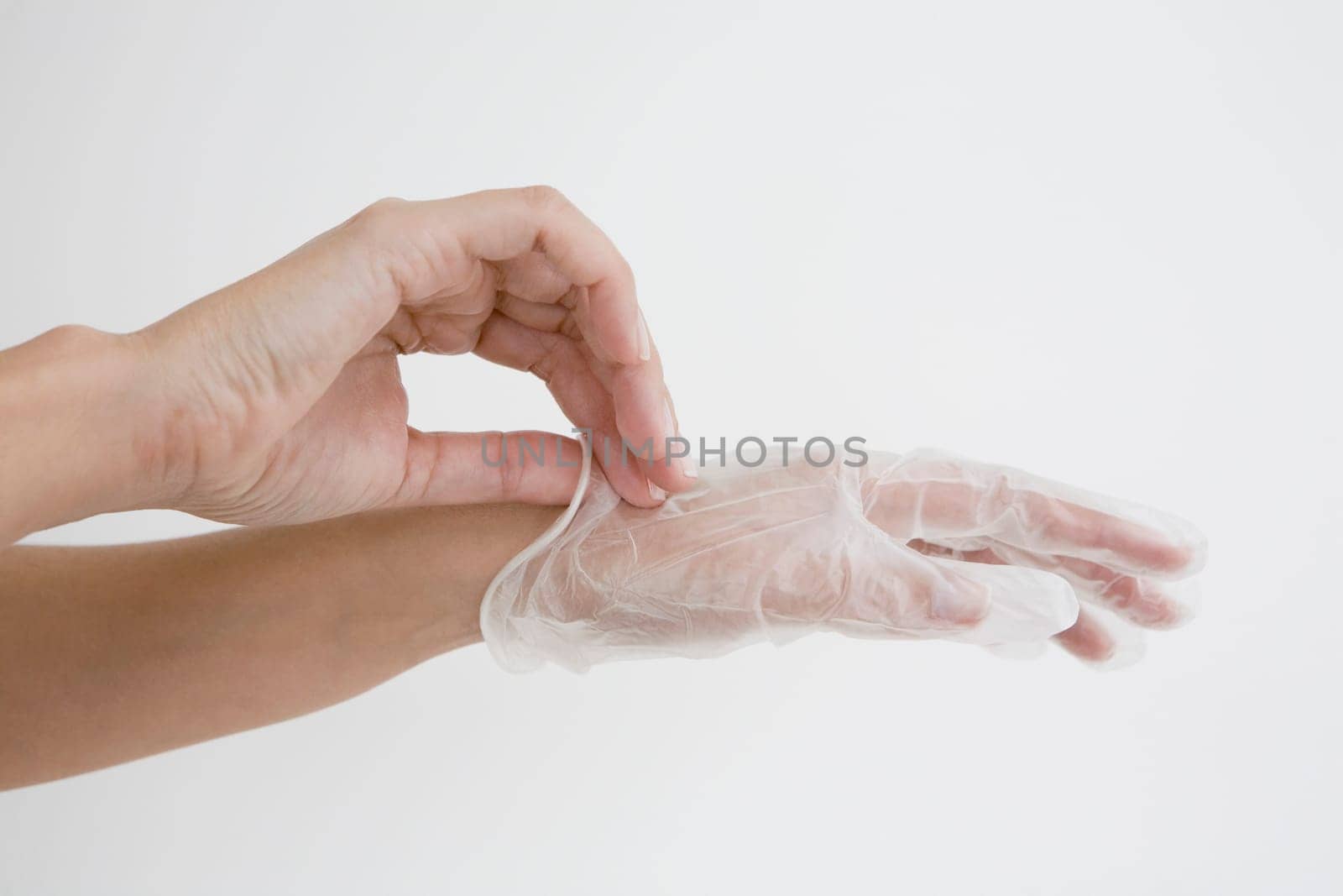 Close-up of a person's hands putting on a surgical glove