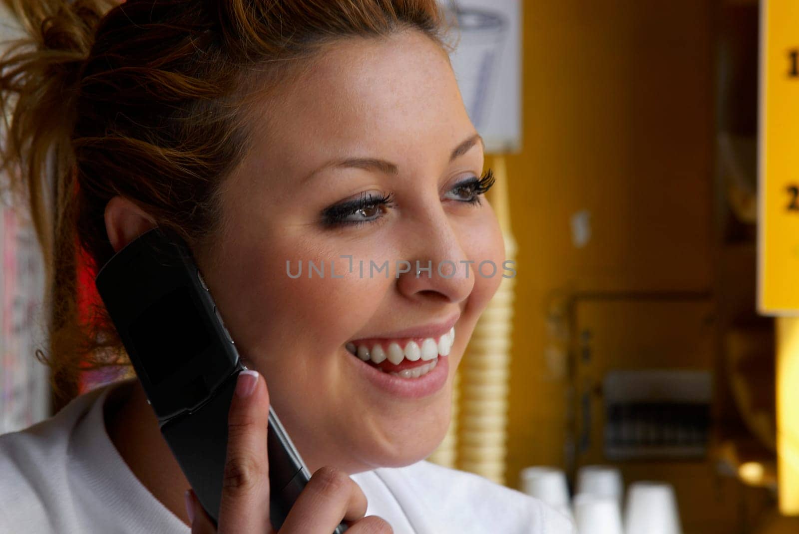 Close-up of a female ice-cream shop owner talking on a mobile phone