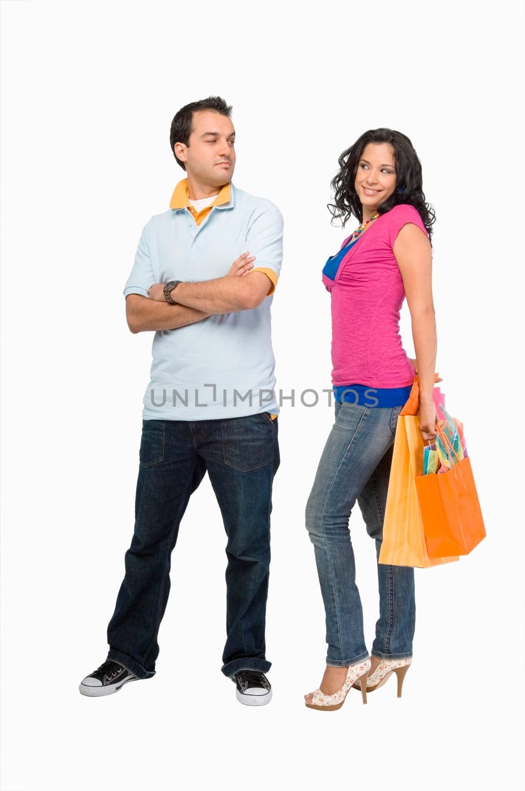 Young woman holding shopping bags with a young man standing beside her