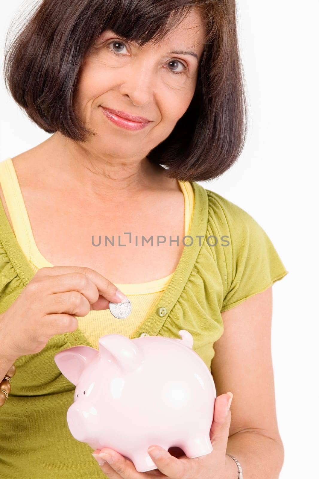 Portrait of a senior woman putting a coin into a piggy bank