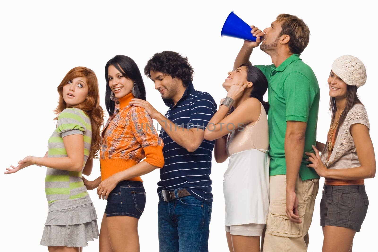 Side profile of a mid adult man shouting into a megaphone between his friends
