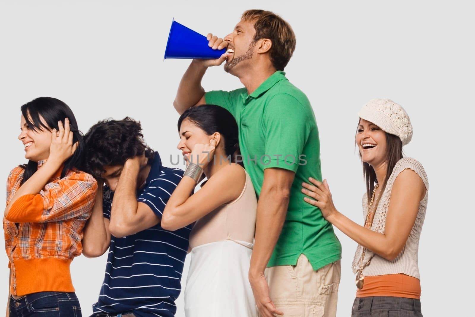 Side profile of a mid adult man shouting into a megaphone between his friends