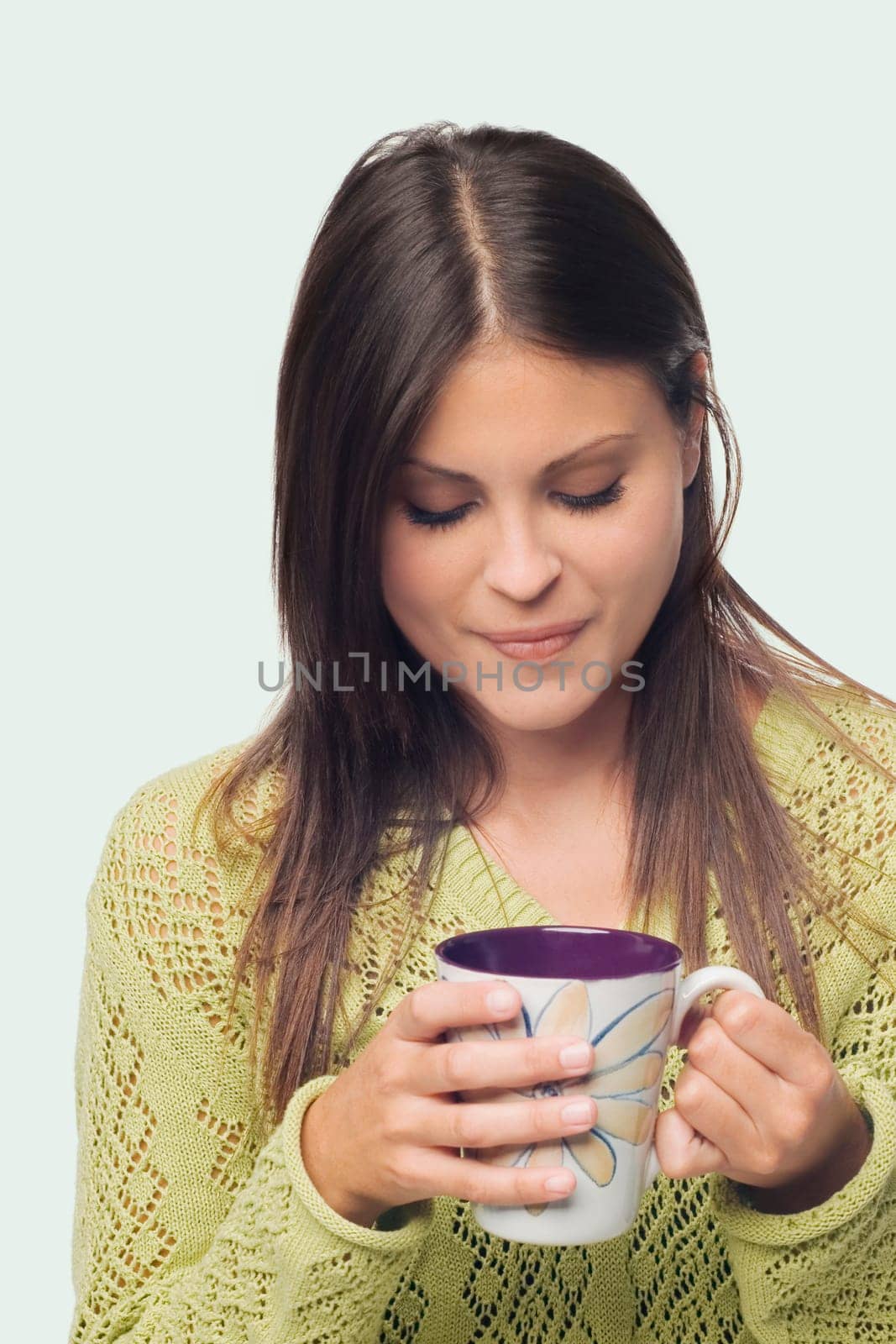 Close-up of a young woman standing and holding a cup of coffee