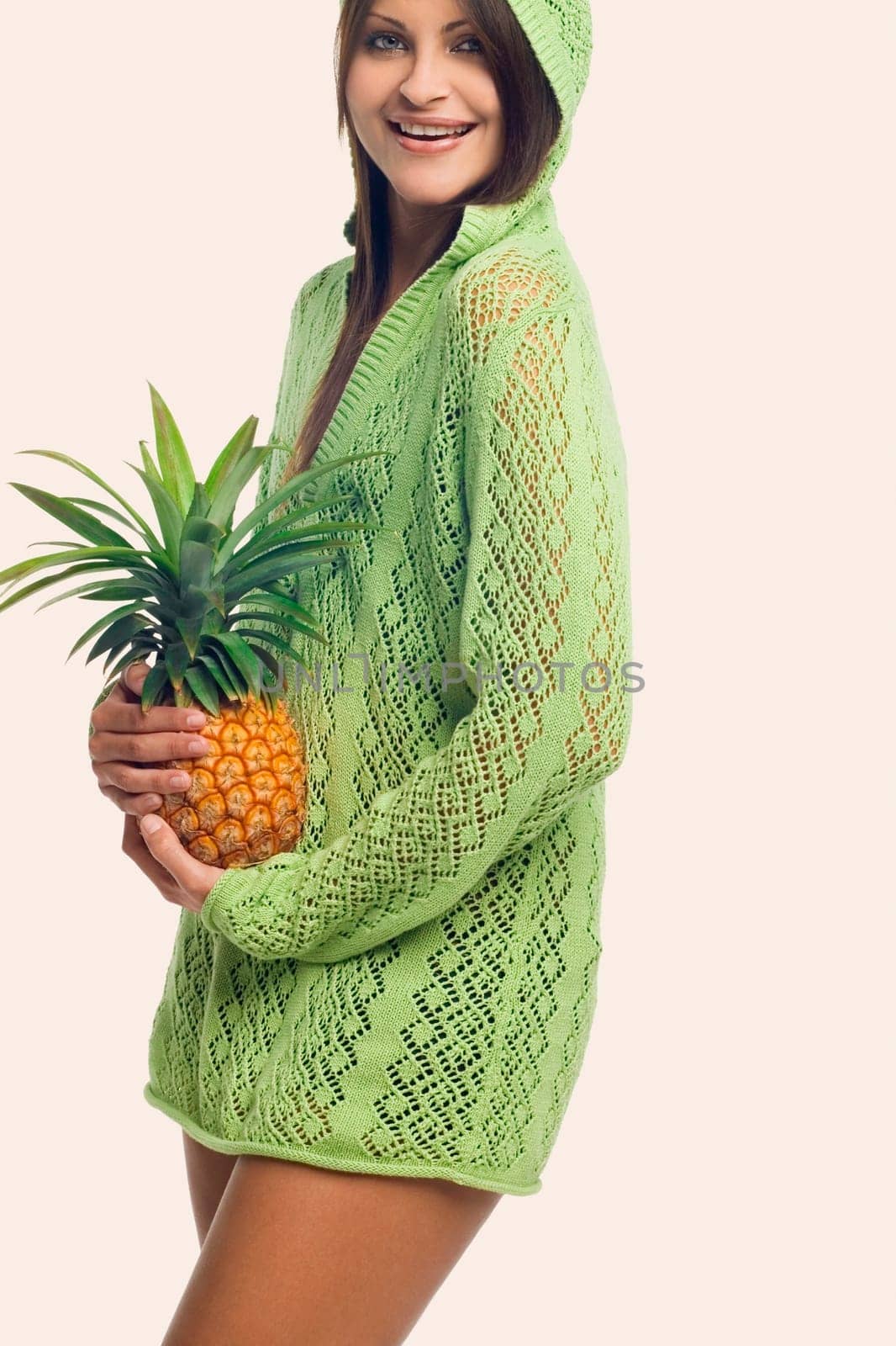 Portrait of a young woman standing and holding a pineapple