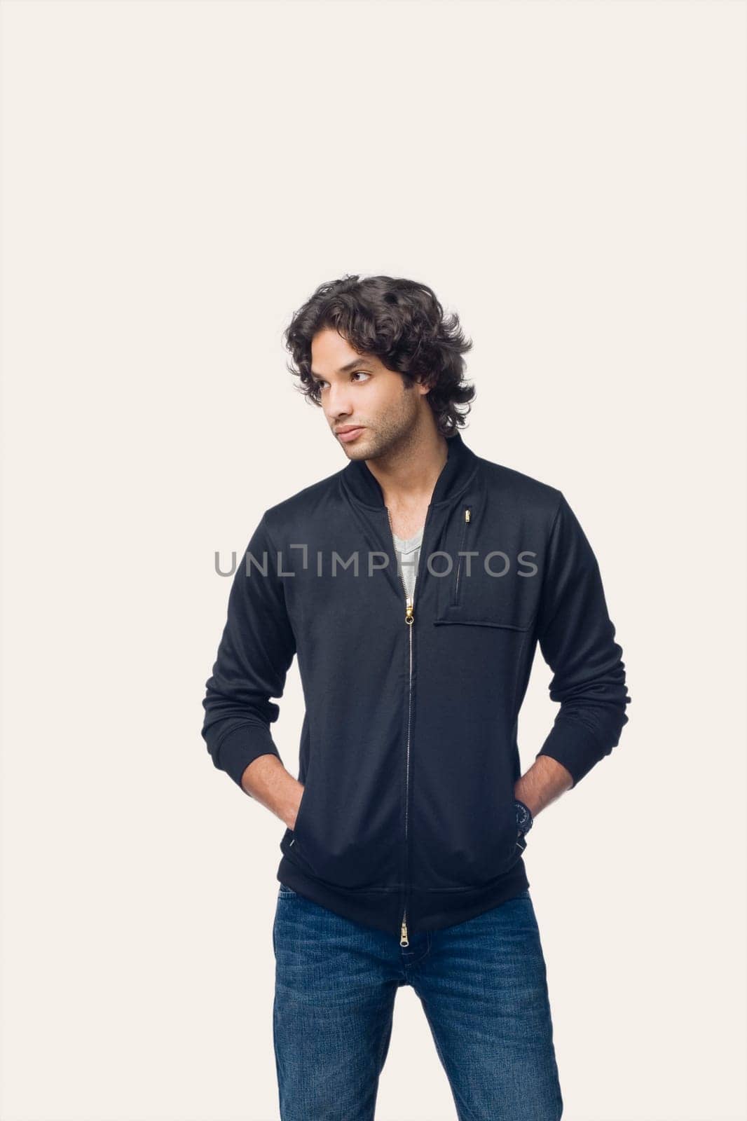 Close-up of a young man standing with his hands in his pockets