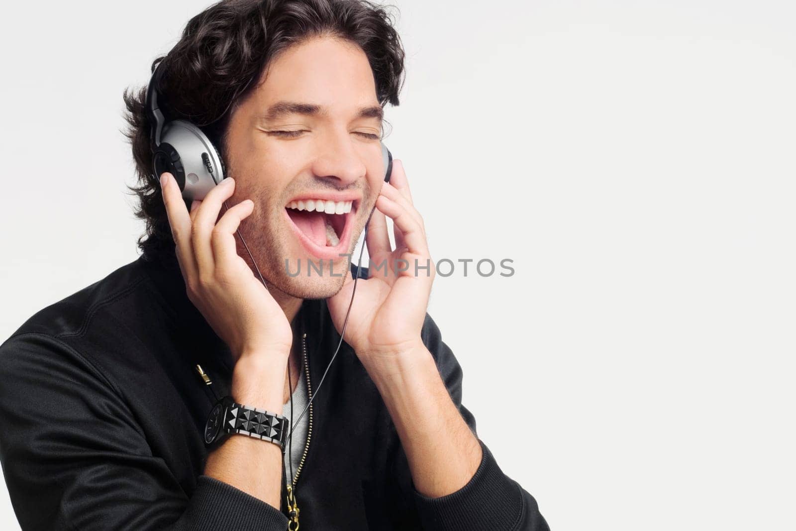 Close-up of a young man listening to music and laughing