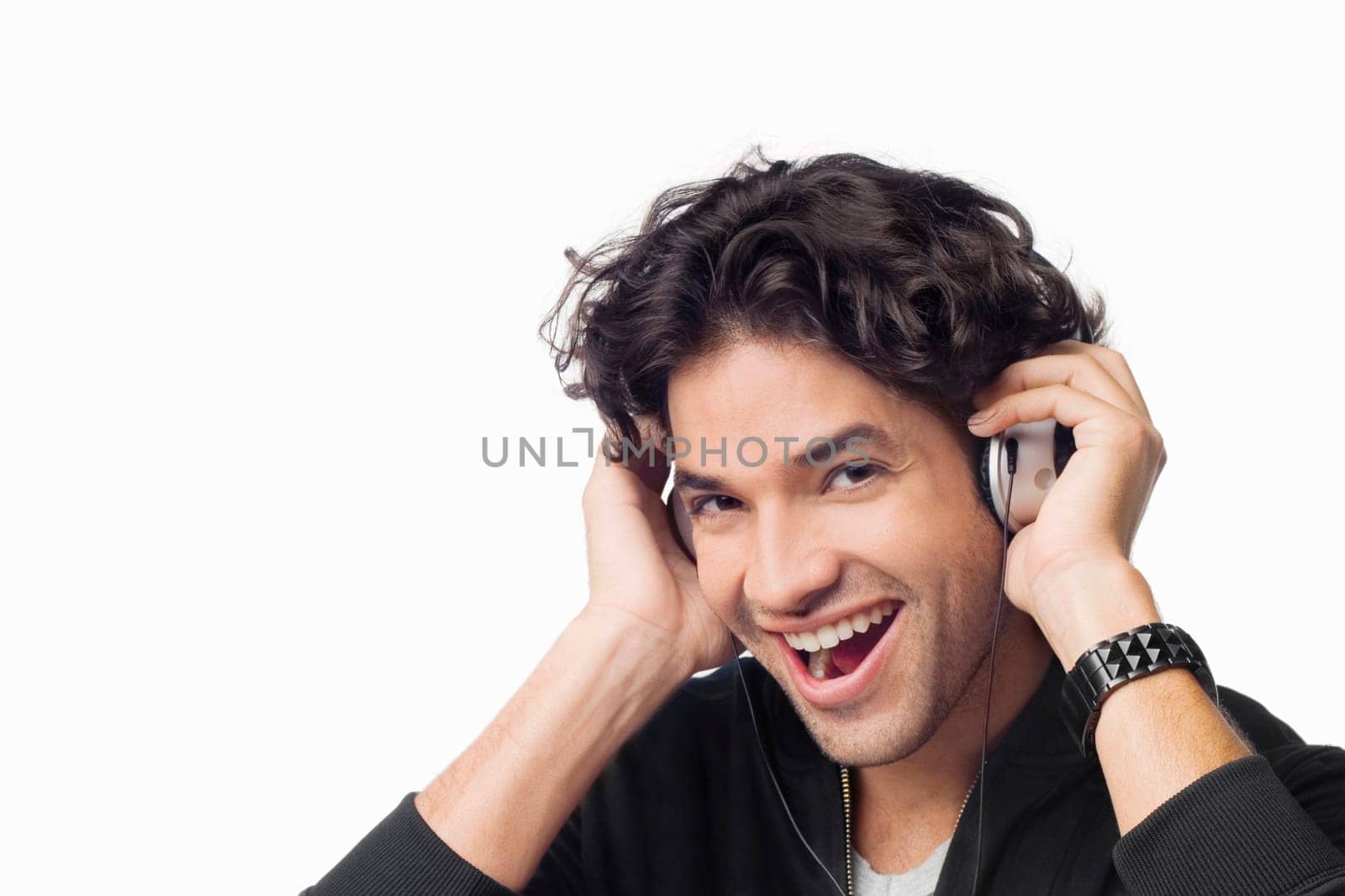 Portrait of a young man listening to music and laughing